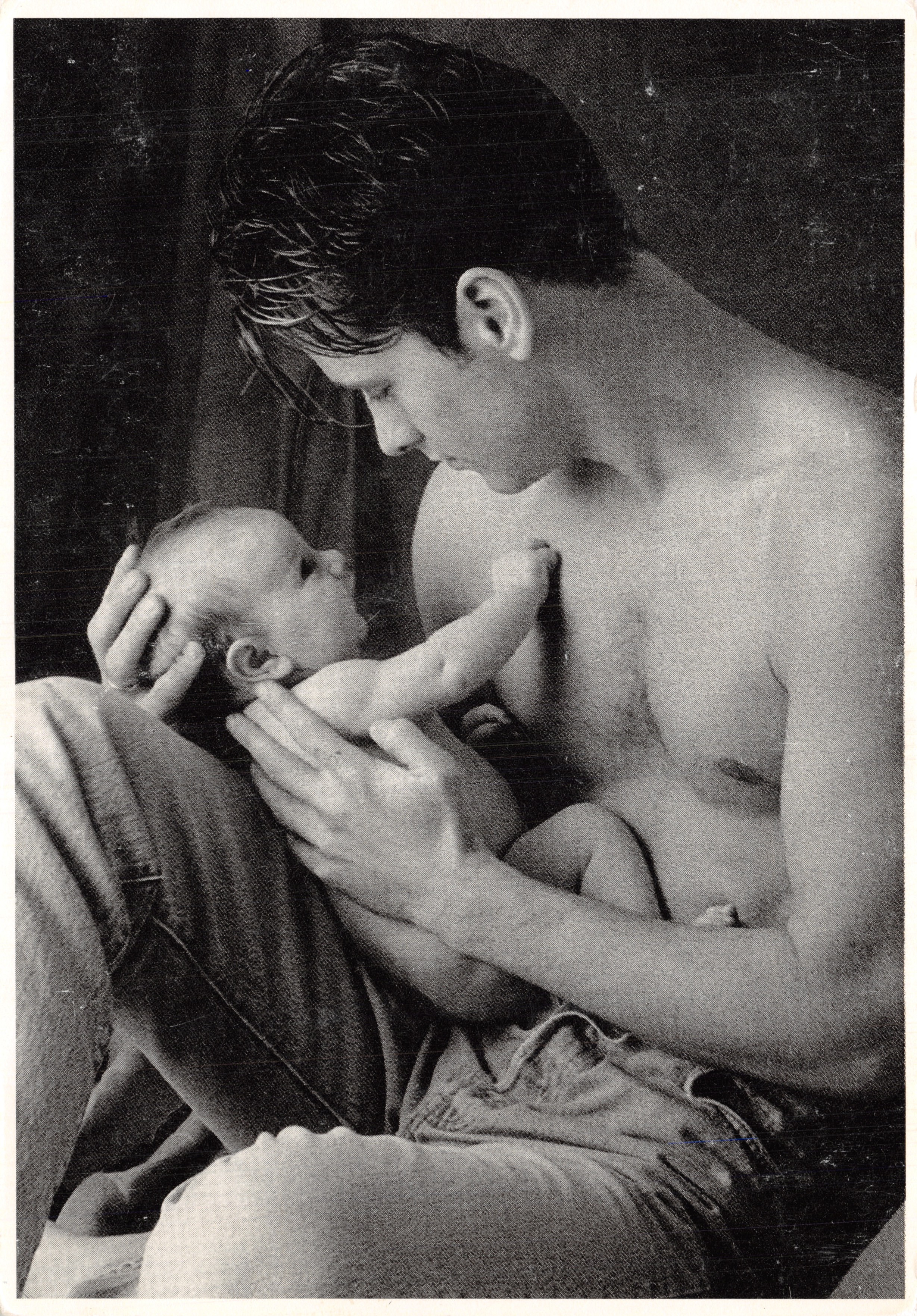Un uomo che allatta un bambino — scena intima in nero e bianco — editore Fitting Image, n. 64714