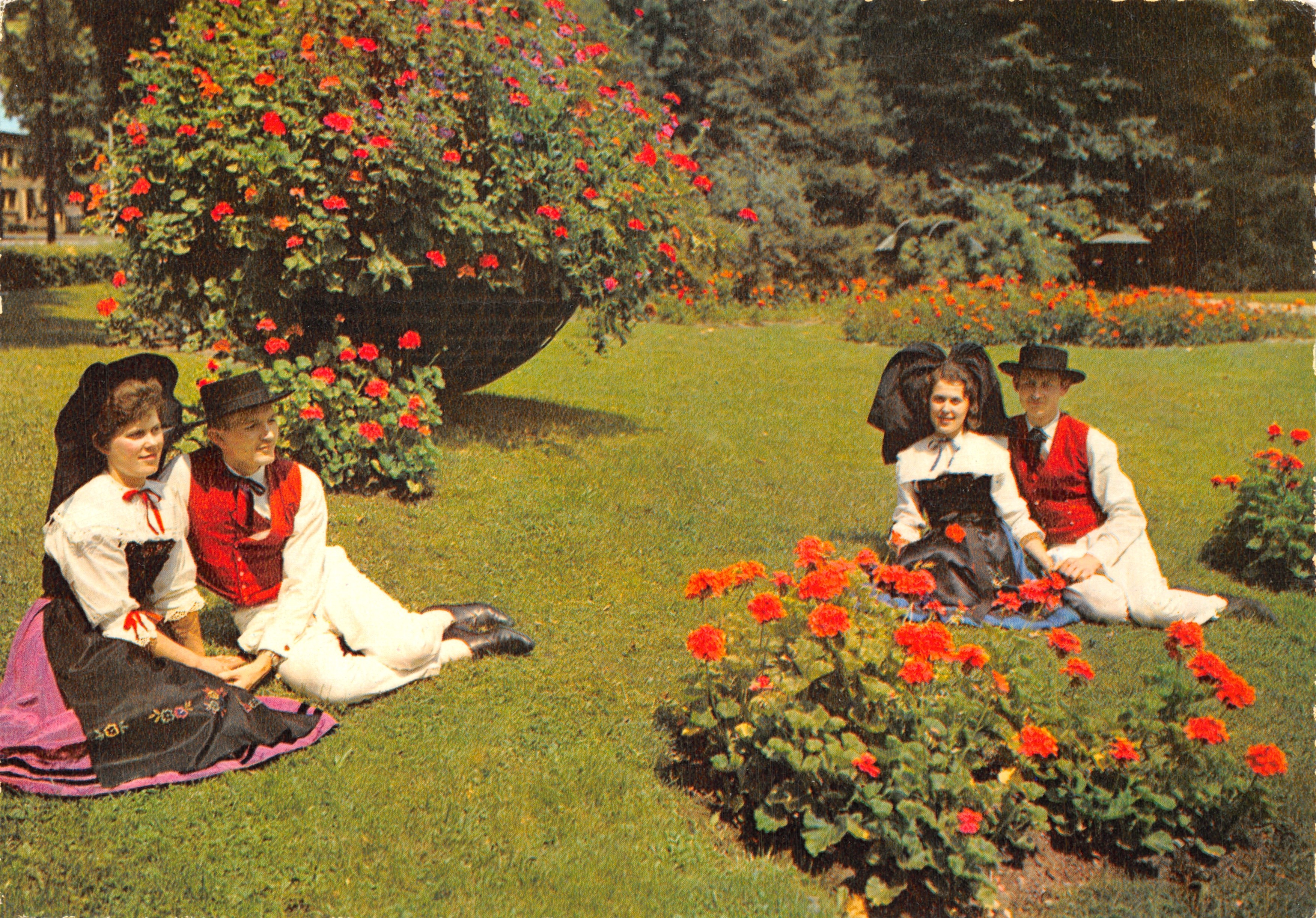 Parejas en trajes folclóricos — escena de un parque con arbustos florales — editor Maracaca, n.º 1205/C