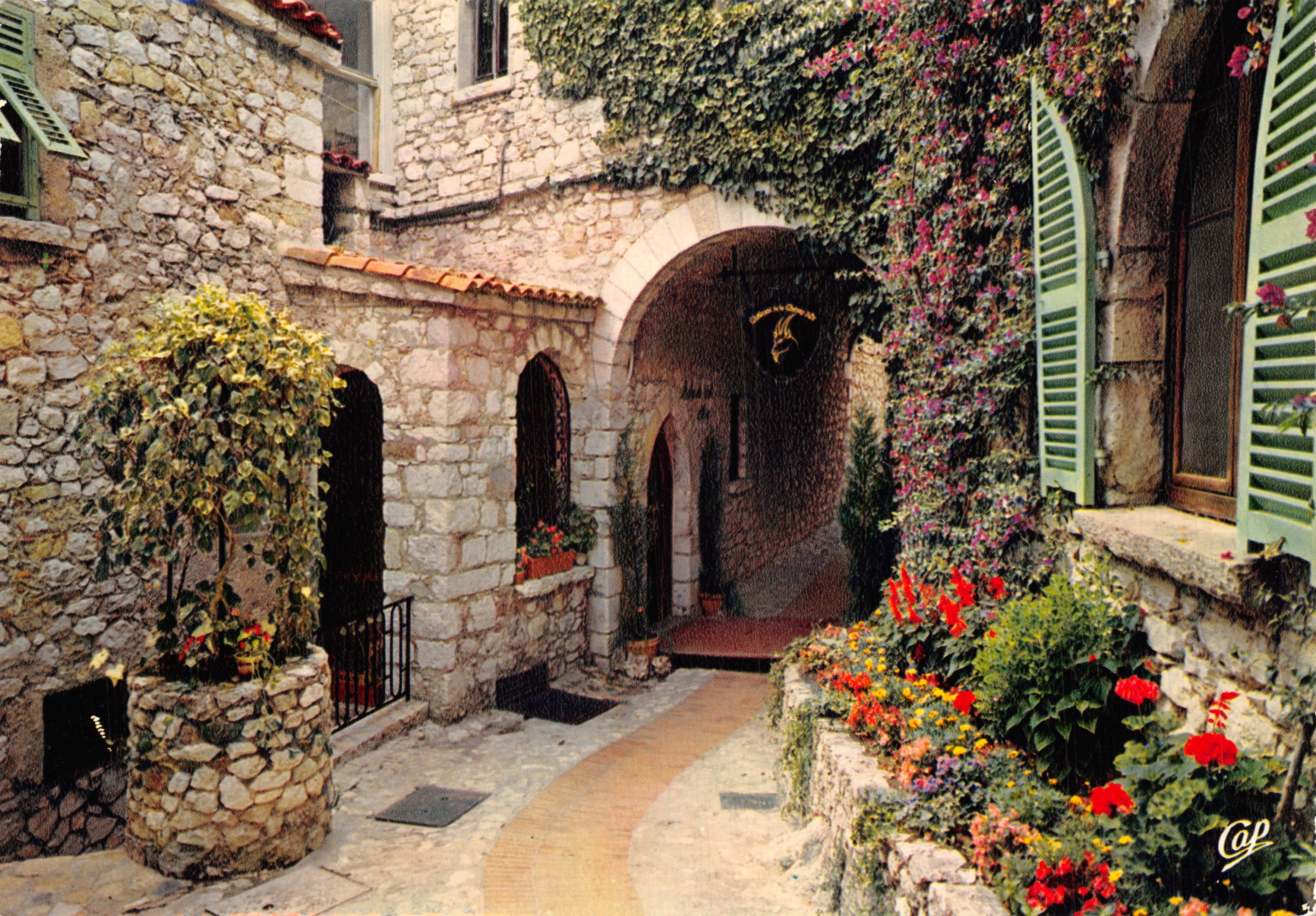 Cortile interno fiorito — Edificio in pietra con arcate e persiane verdi — Editions CAP, n. (70)