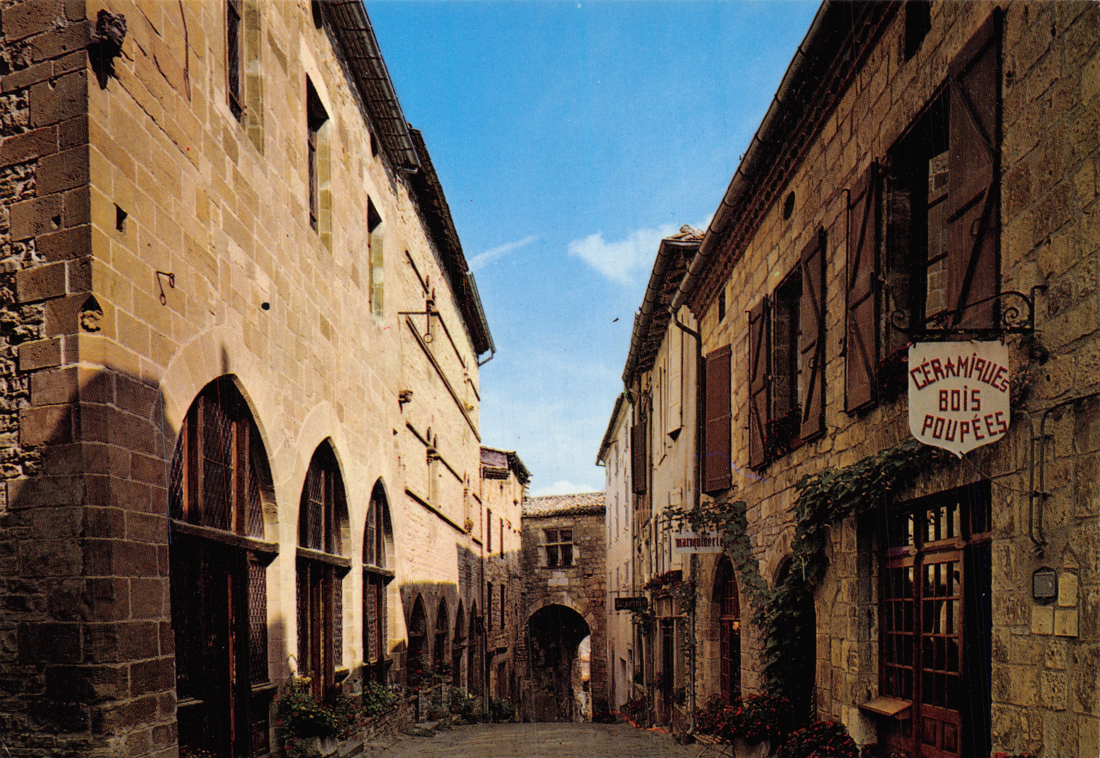 Cordes-sur-Ciel — calle medieval con arcos y tienda de cerámica y madera para muñecas — editor APA-COLOR, n° 81 CO-1028