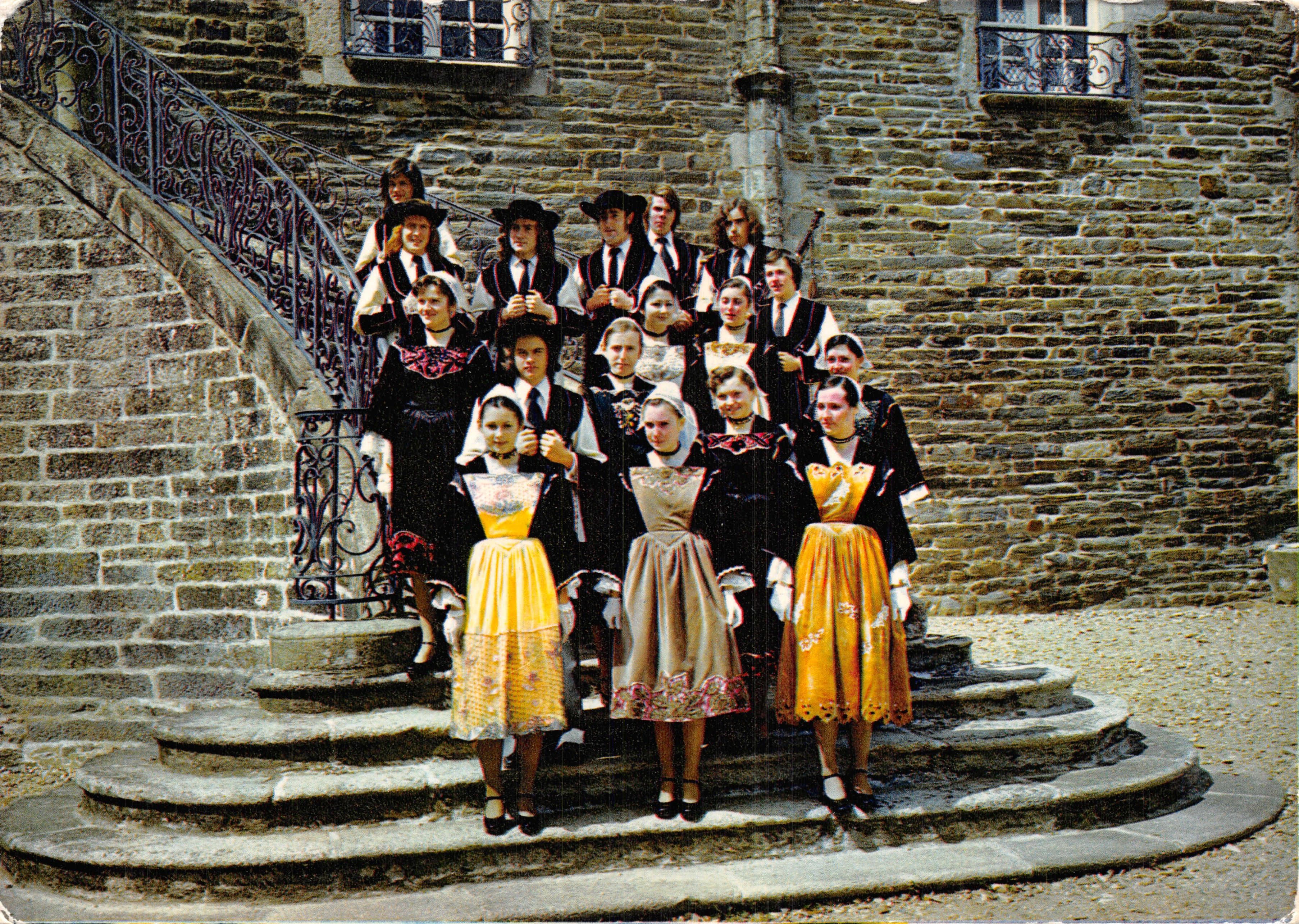 Gruppe junger Menschen in traditionellen Kleidern — vor einer Steintreppe mit Eisenbalustrade — Verleger nicht sichtbar