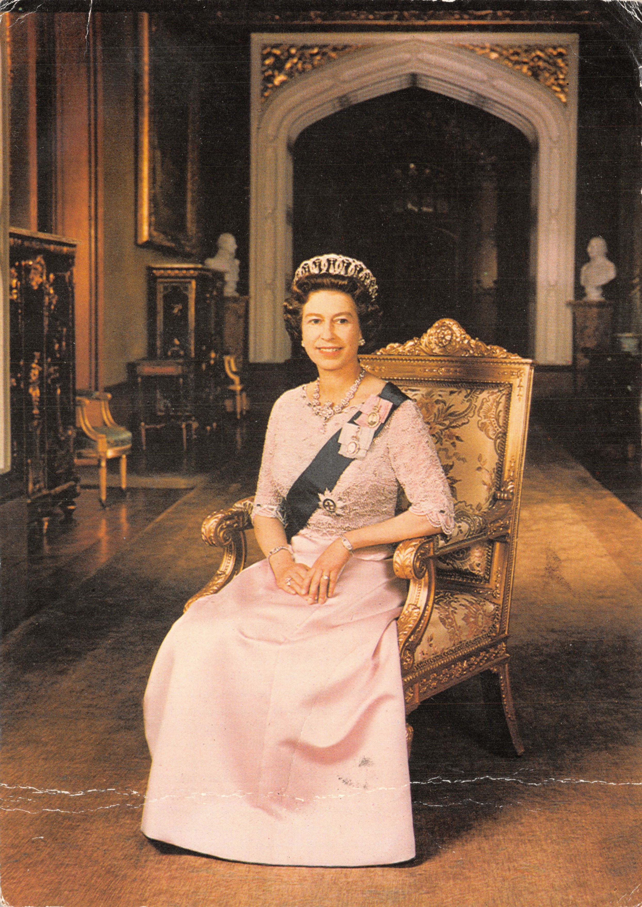 La Regina Elisabetta II — in abito rosa e corona, seduta su una sedia dorata in un salone riccamente decorato — Charles Skilton's Postcard Series n°503