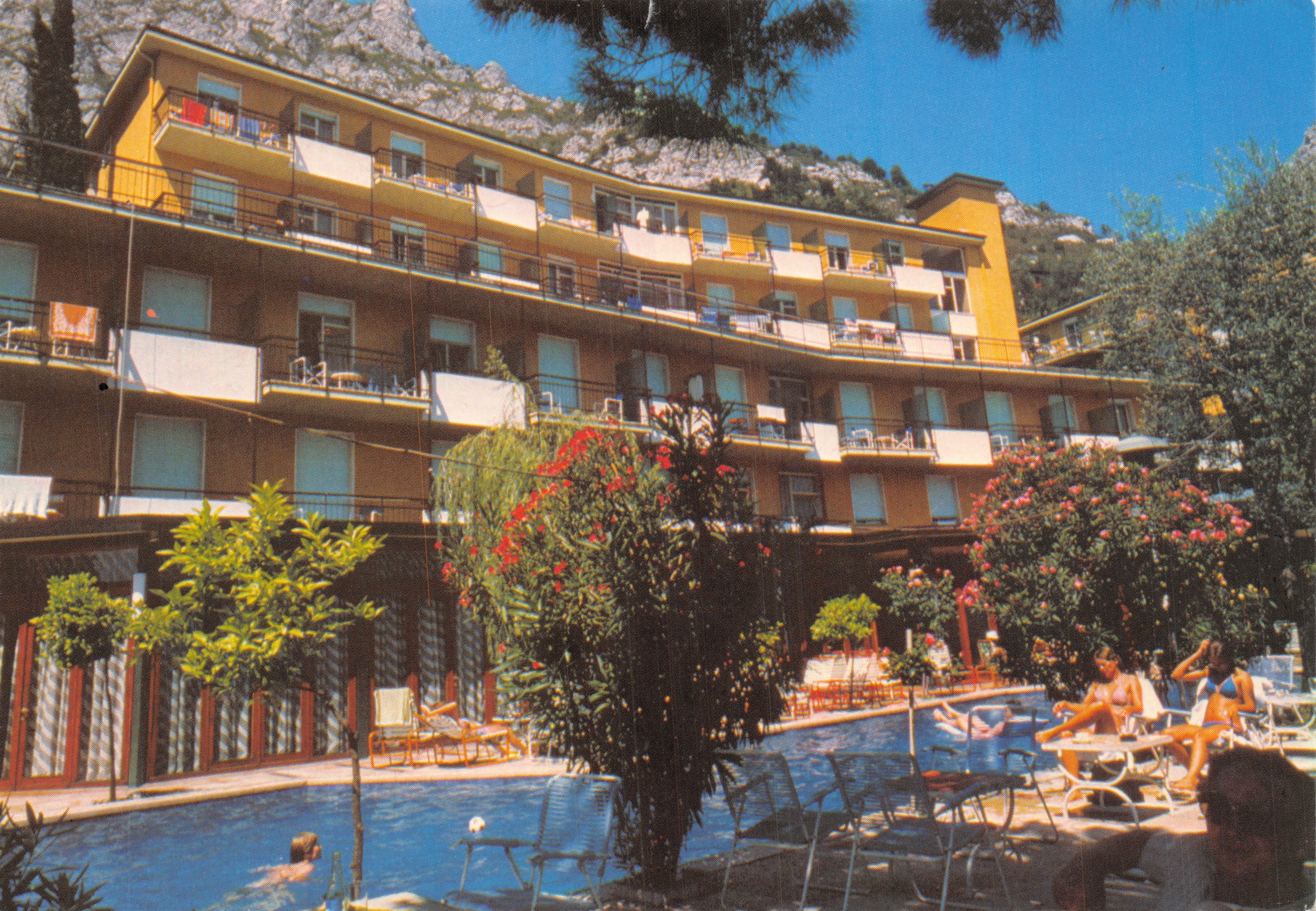 Hôtel Cristina — vue de la piscine et du bâtiment avec montagnes en arrière-plan — éditeur CHINCHERINI GERMANO