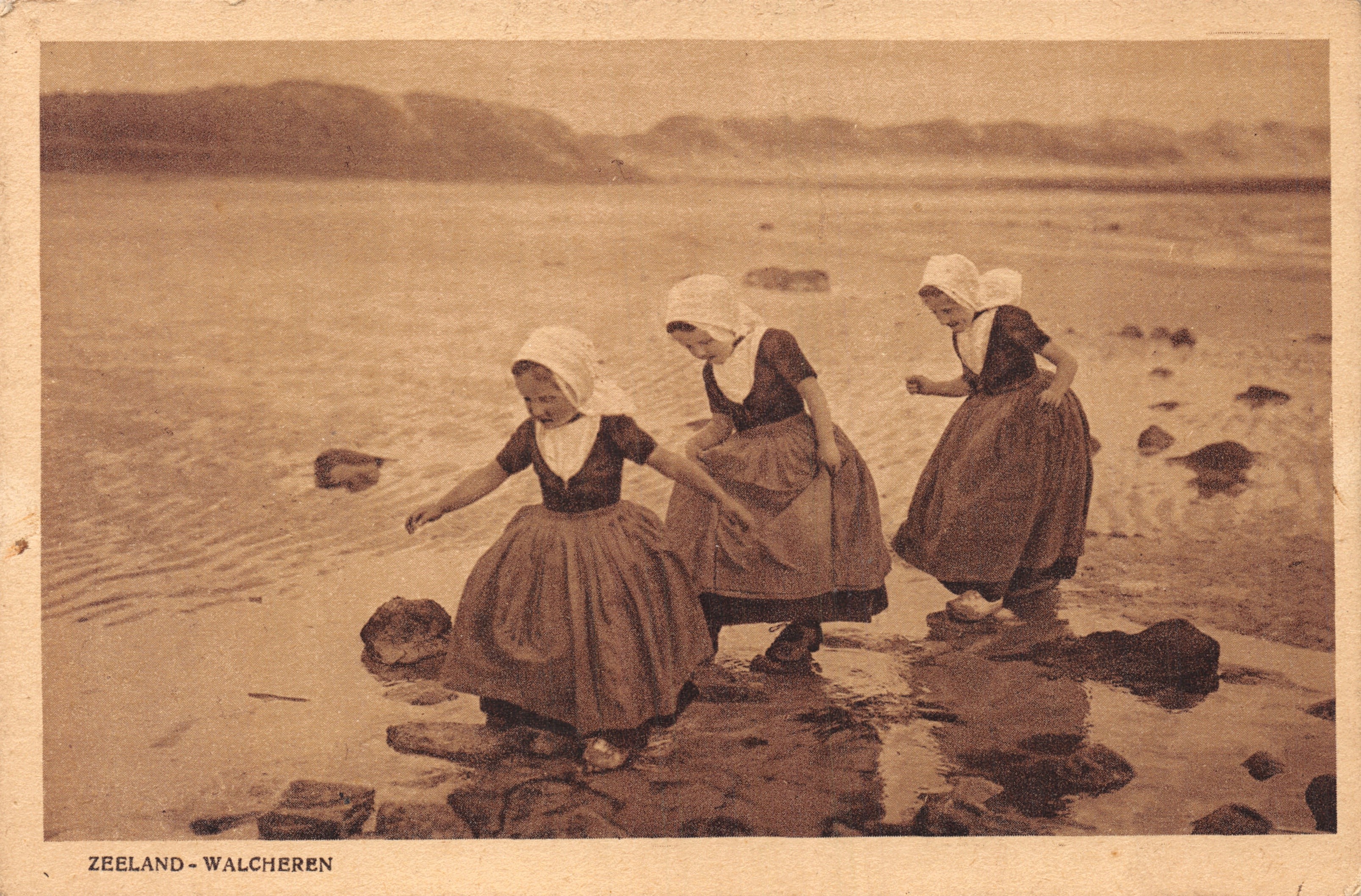 Tres jóvenes chicas en ropa tradicional — playa rocosa de Zeeland-Walcheren — editor Firma F. B. den Boer, Middelburg, serie 28
