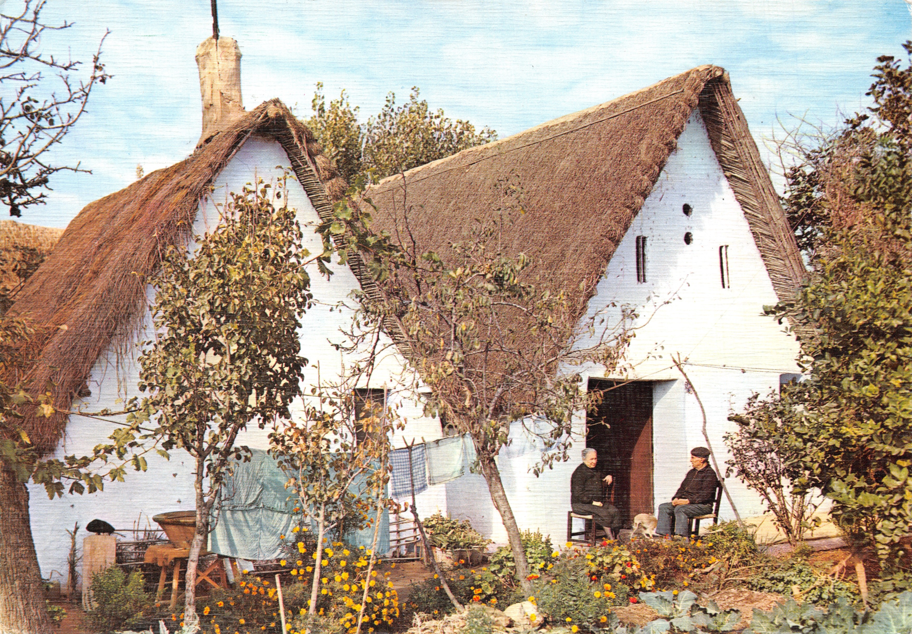 Cottage à toit de chaume — jardin avec deux hommes assis — éditeur Ediciones ARRIIBAS - S. Guallar