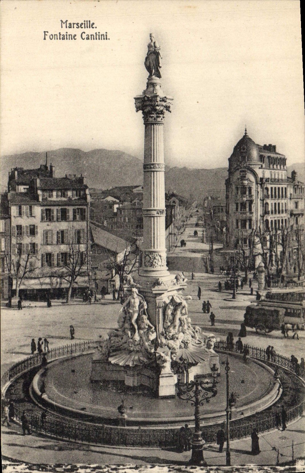 Marseille. Fontaine Cantini. — Vue de la fontaine monumentale avec colonne et statues, au centre d'une place urbaine.