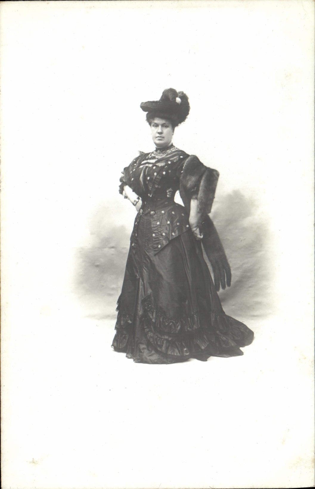 Femme en robe sombre et chapeau à plumes — Éditeur H. Exnort, 58 rue Gioffredo — N° de série 06