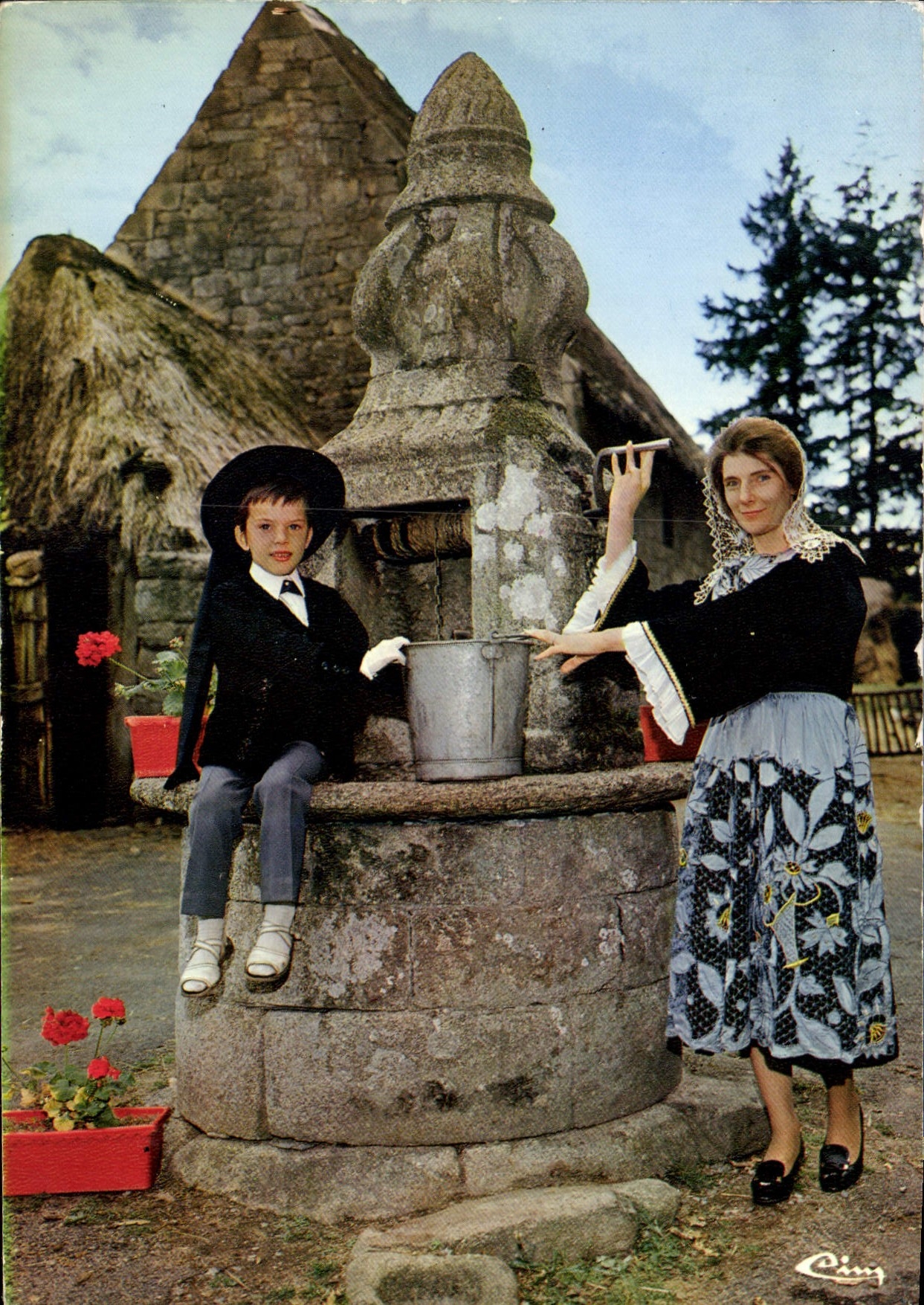 Femmes et enfants en costume breton — près d'une fontaine — éditeur CIMCOLOR