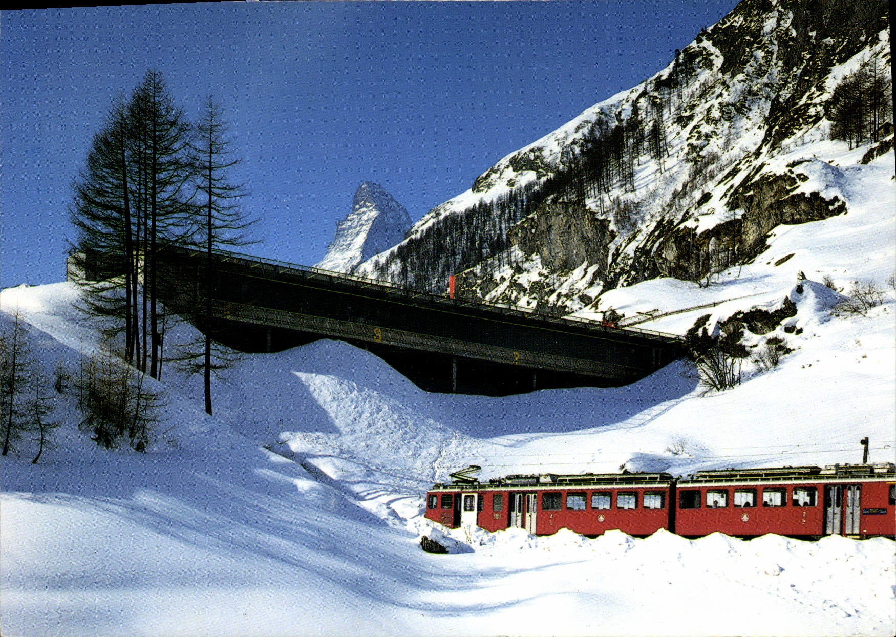Train de la Brigue-Visp-Zermatt-Bahn — pont et montagne enneigée — Photo Klopfenstein, n°49522