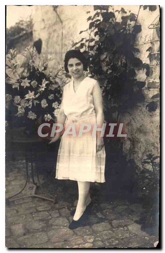 Femme souriante en robe claire — jardin avec fleurs et cage — carte postale datée 8 Juin 1930