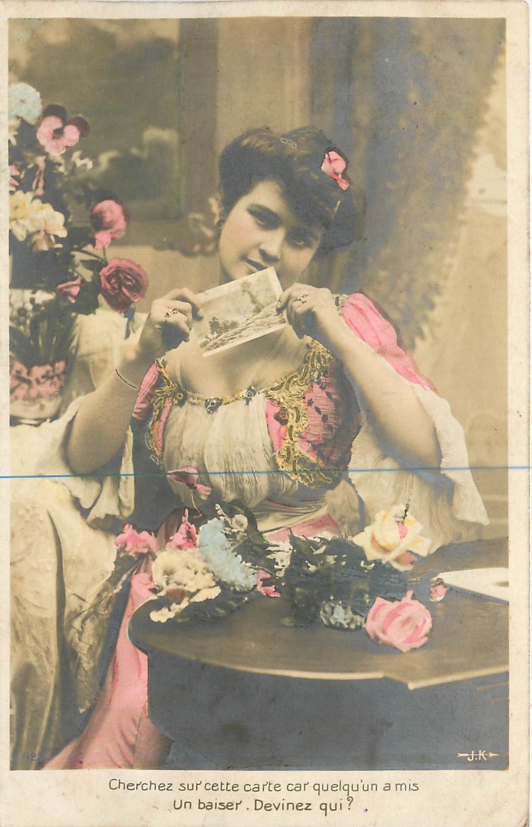 Jeune femme tenant une carte postale — jeu de devinette — J.K.