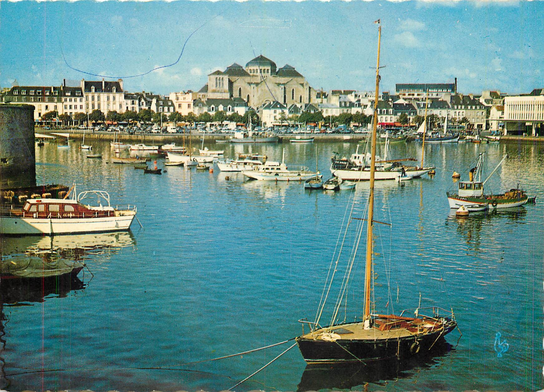 CPM Concarneau Le Port l'Avenue Pierre Gueguen et l'Eglise du Sacre Coeur de Marie Bateaux