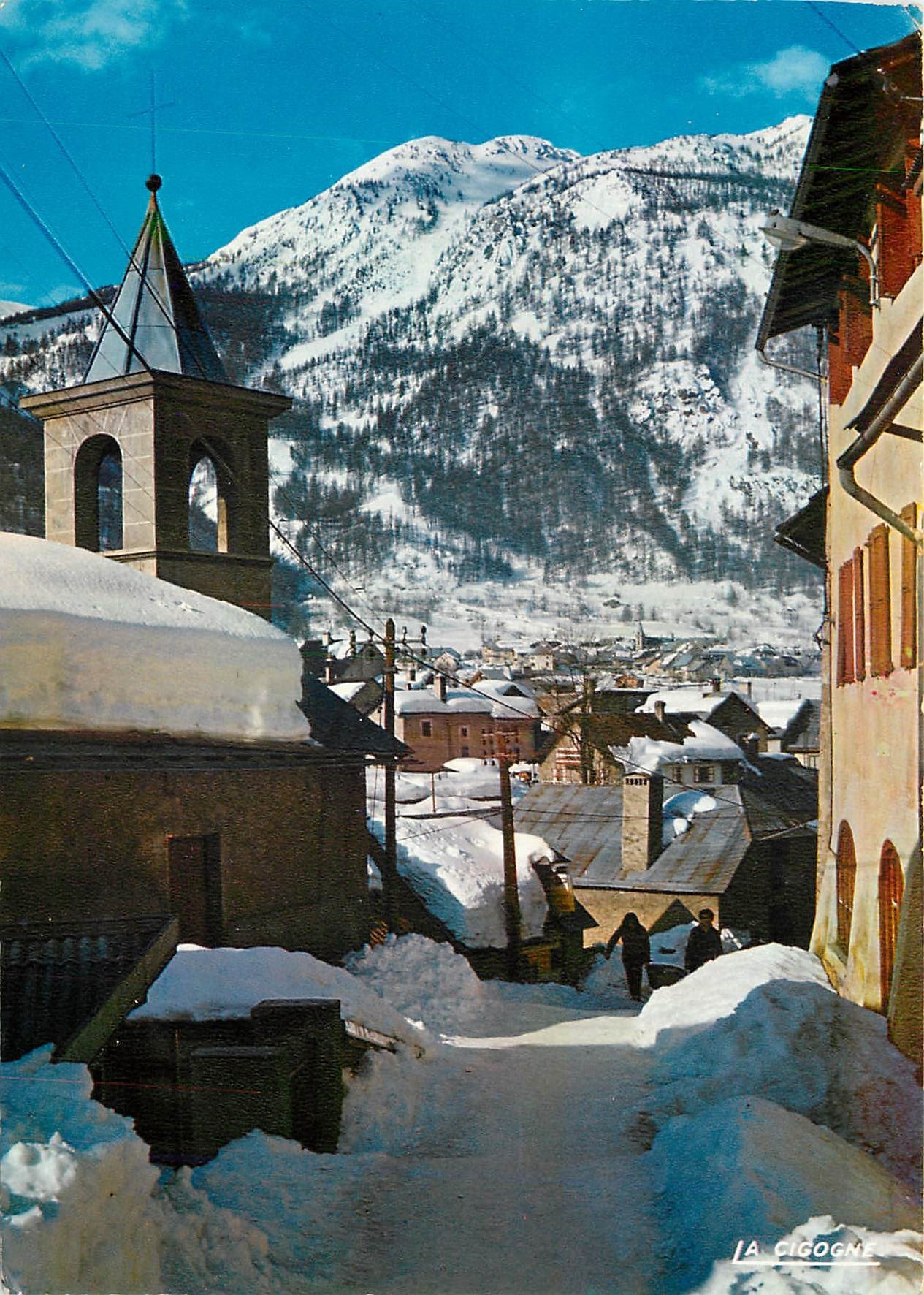 La Cigogne — Vue d'une rue du village enneigé — Éditions HACHETTE