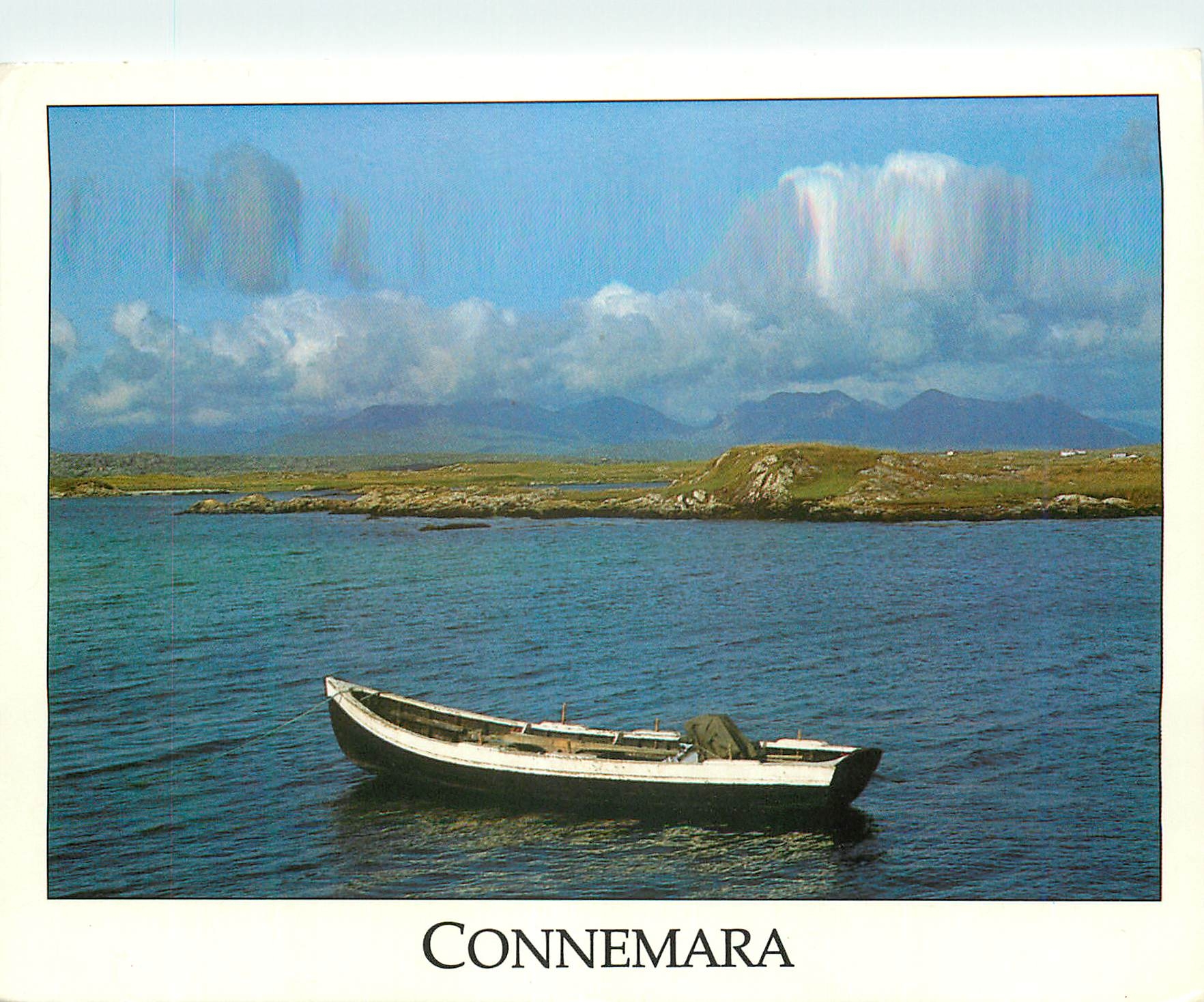 CPM Connemara Small traditional fishing boat in Mannin Bay near Clifden with the Twelve Pin Mountains of Connemara in th