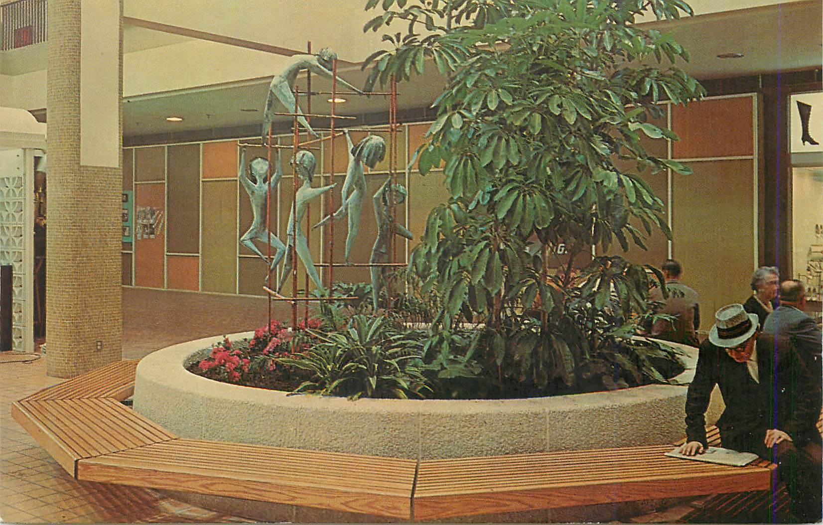 CPM Life size scultured children climb amid plantings of phoenix roebellini palms and scheffleras on the mall at midtown