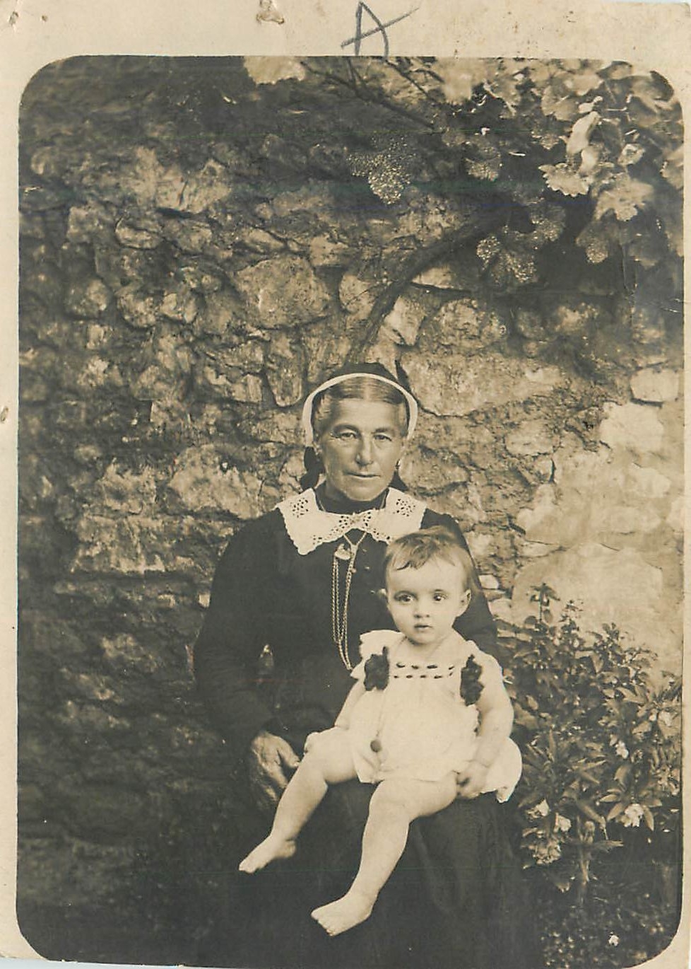 Femme et enfant — devant mur de pierres — carte postale