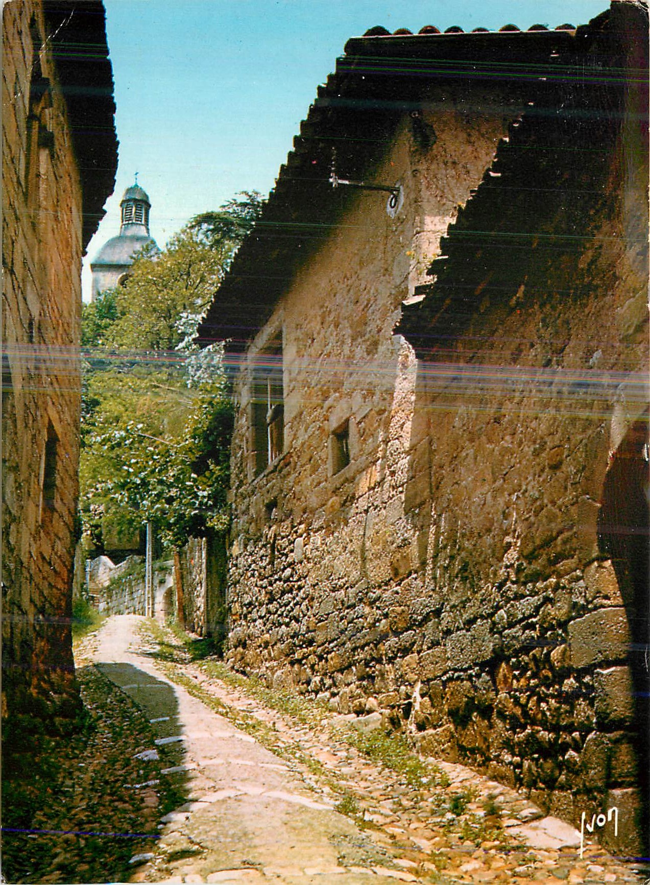 Rue Delzhenes bordée de vieux hôtels — clocher de l'église Notre-Dame du Puy — Éditions d'Art Yvon