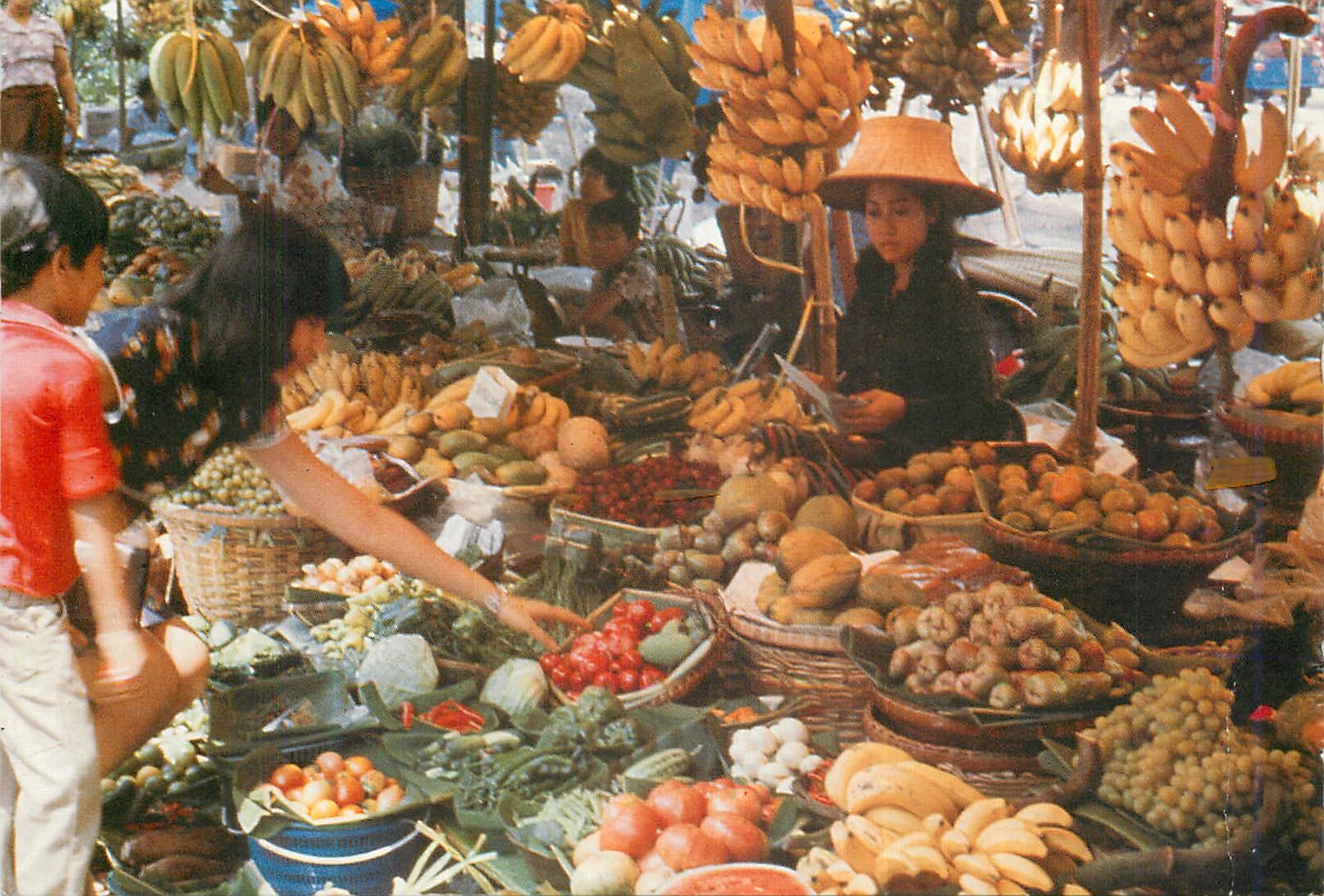CPM An inviting array of luscient tropical fruits and vegetables shoppers at the week end market 