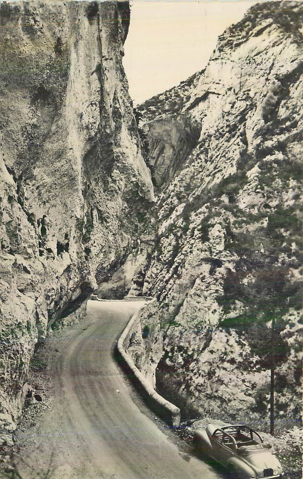 Route encaissée entre falaises — voiture classique — éditeur non visible
