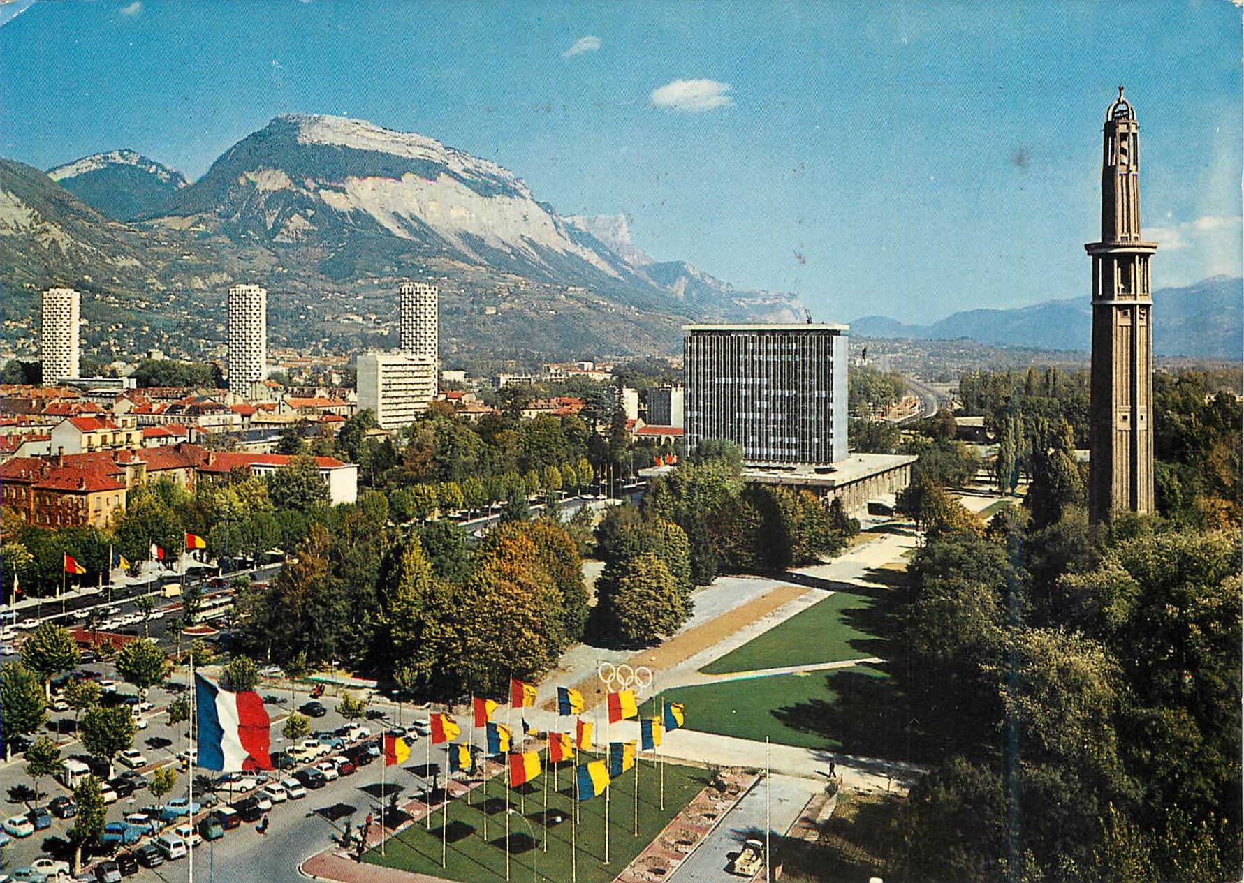 Stadt Alpes — Panoramablick mit Uhrenturm und Berg im Hintergrund — Verlag nicht sichtbar