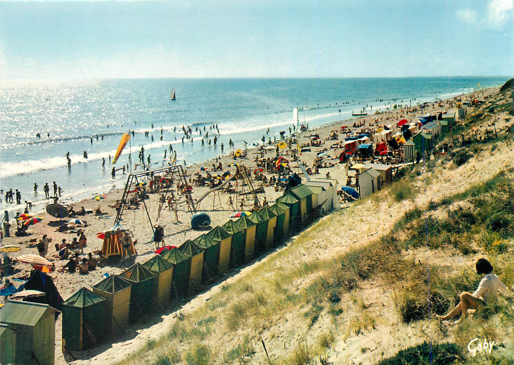 Plage animée — cabanes de plage et jeux — Gaby