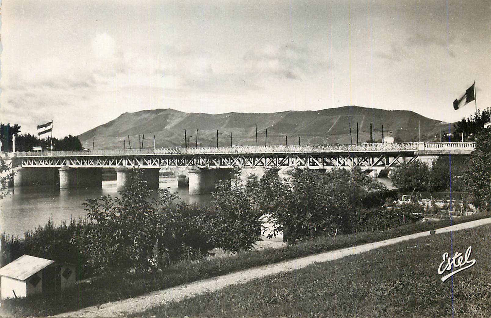 Pont métallique sur un fleuve — montagnes en arrière-plan — Estel