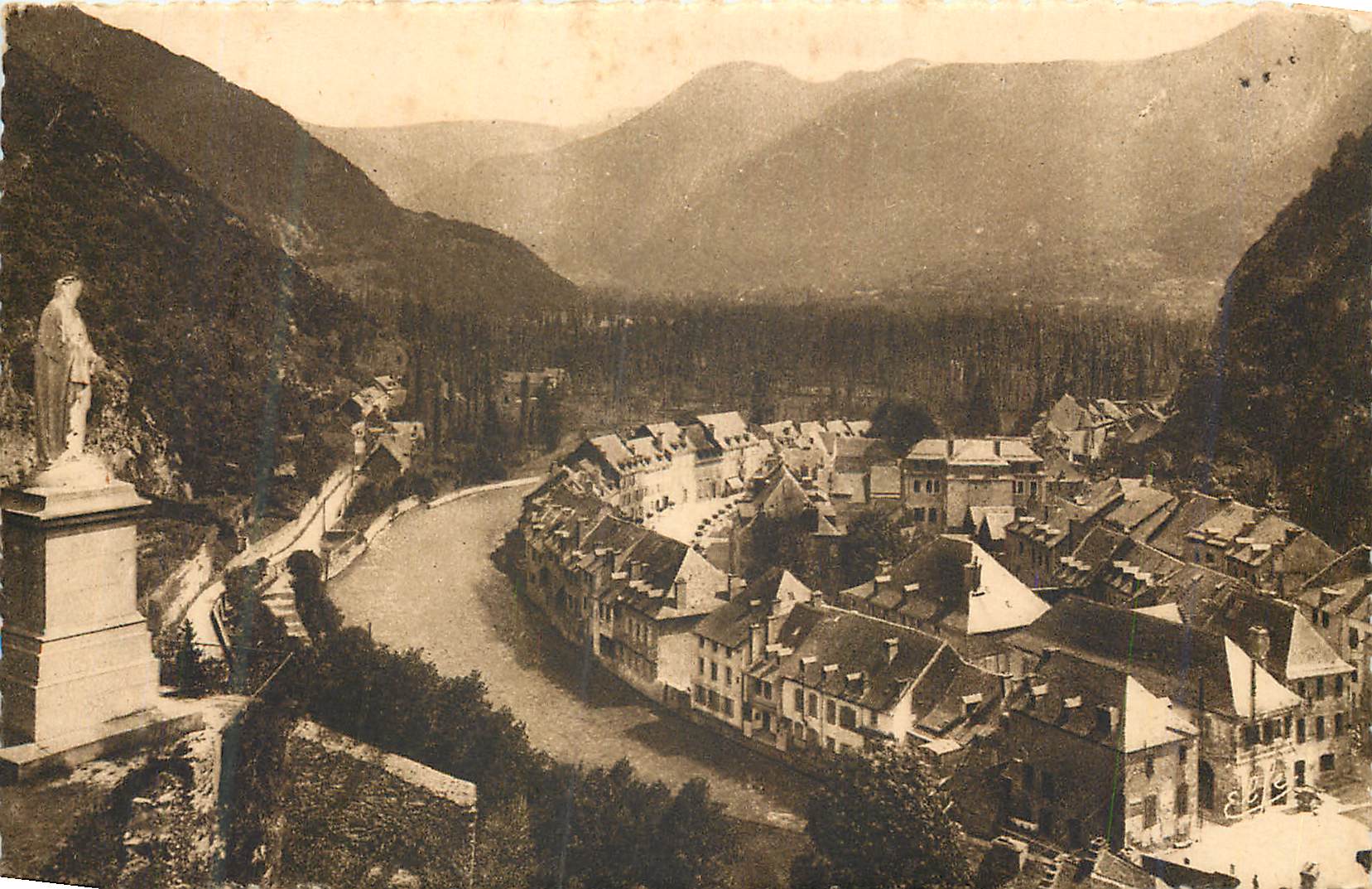 Village encaissé dans un vallon montagneux — statue sur un piédestal à gauche — éditeur non identifiable