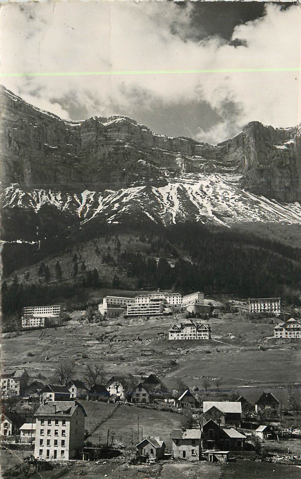 Village alpin encaissé — montagnes enneigées en arrière-plan — éditeur non identifiable
