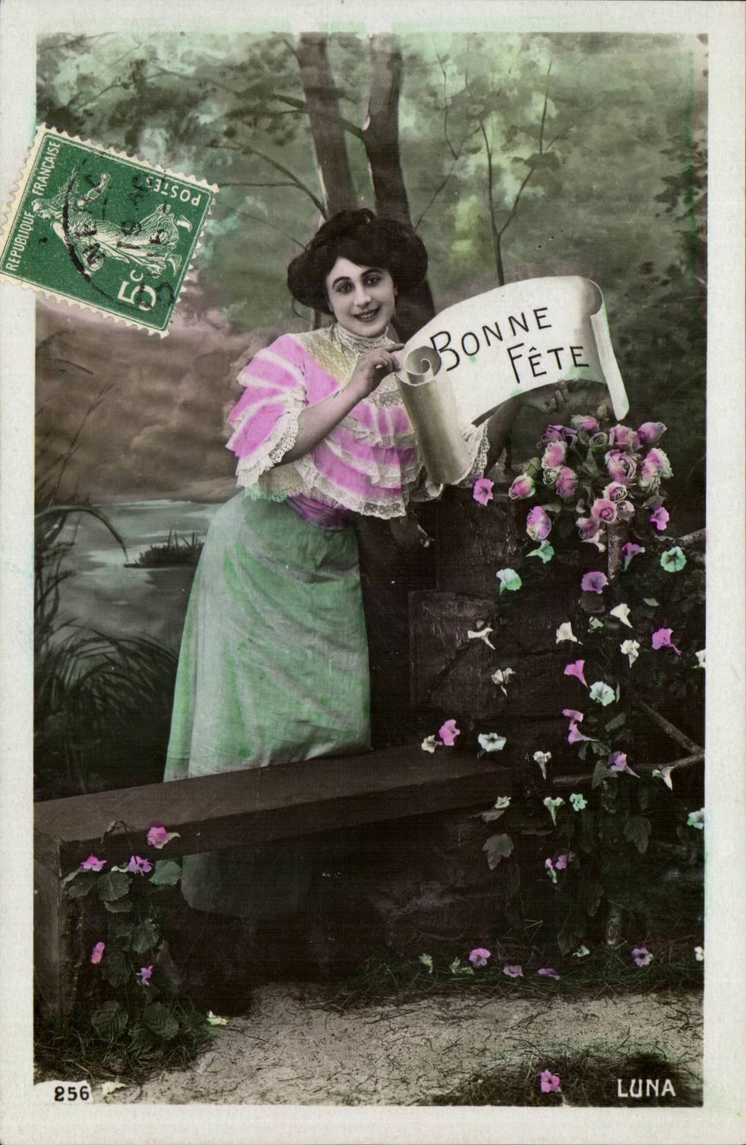 Woman in a pink and green dress — holding a scroll with 'BONNE FÊTE' — published by LUNA, n° 256