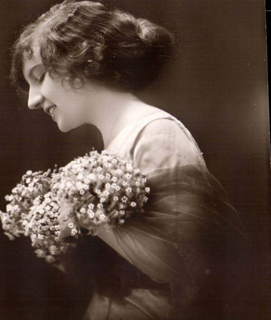 Jeune femme souriante tenant un bouquet — photographie — CPAPHIL