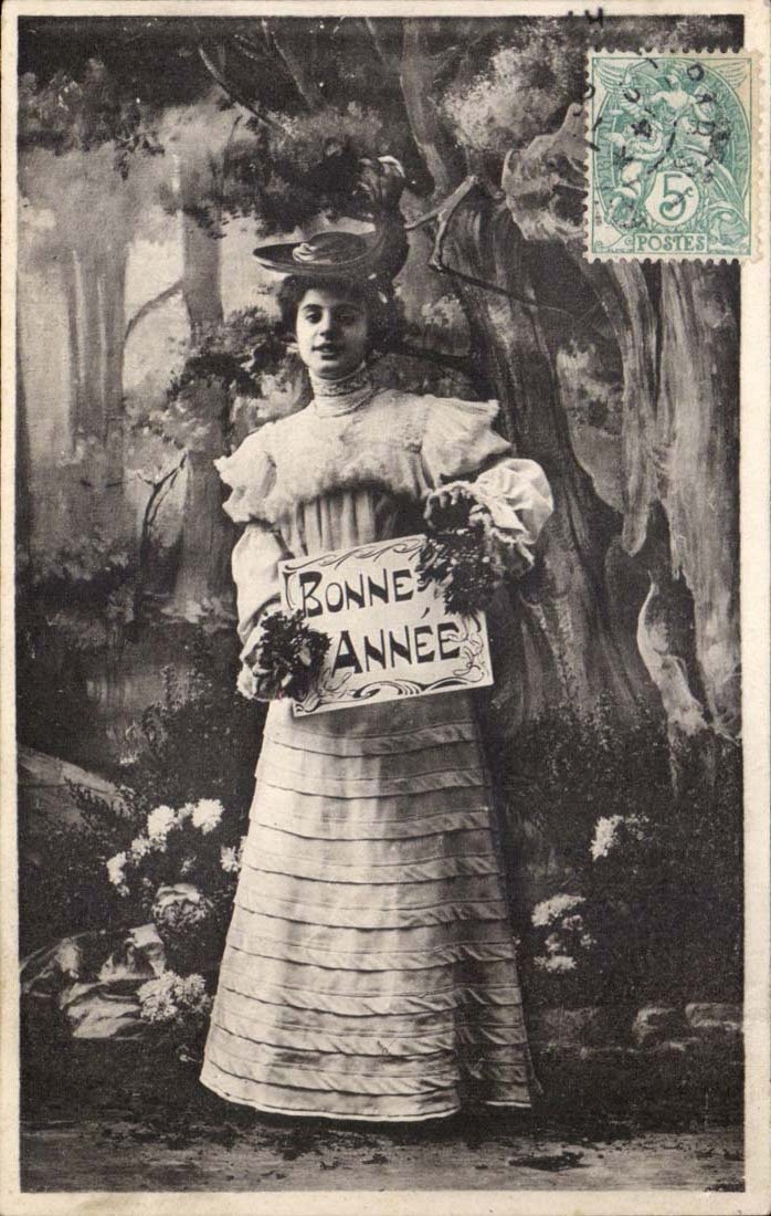 Mujer en vestido con volantes sosteniendo un letrero 'BUEN AÑO' — editor 'Buccès' n°18