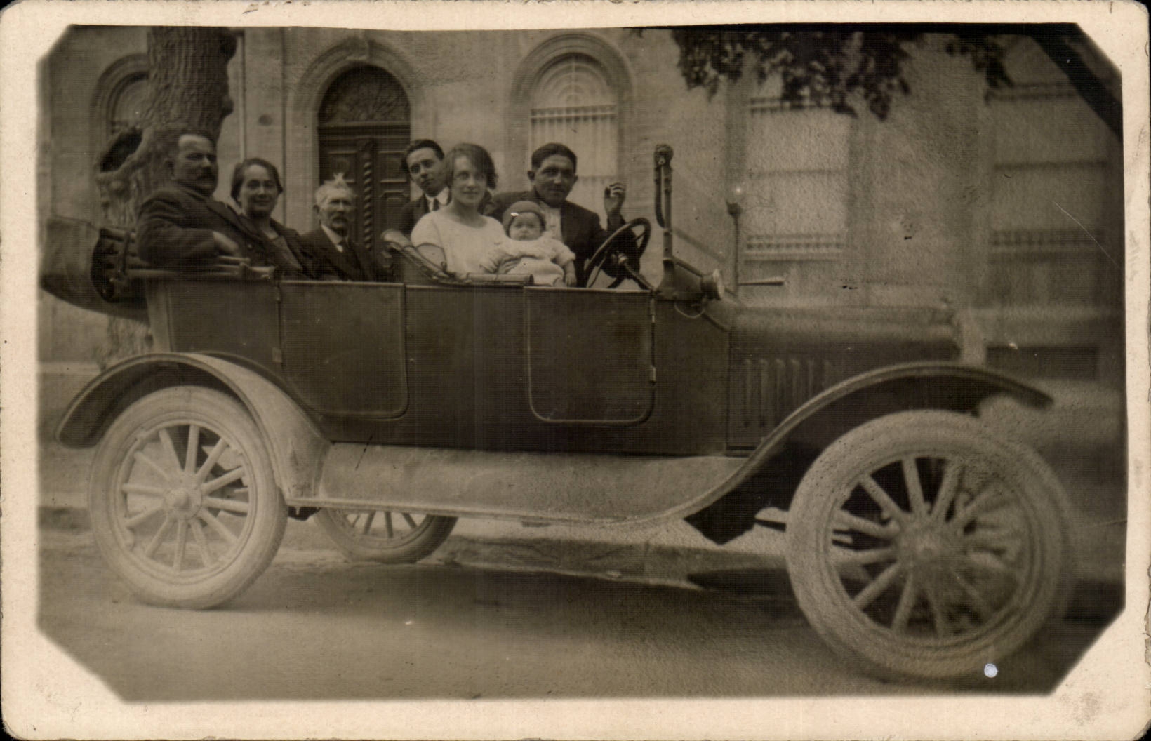 Famille dans une voiture ancienne — éditeur inconnu, n° de série non visible
