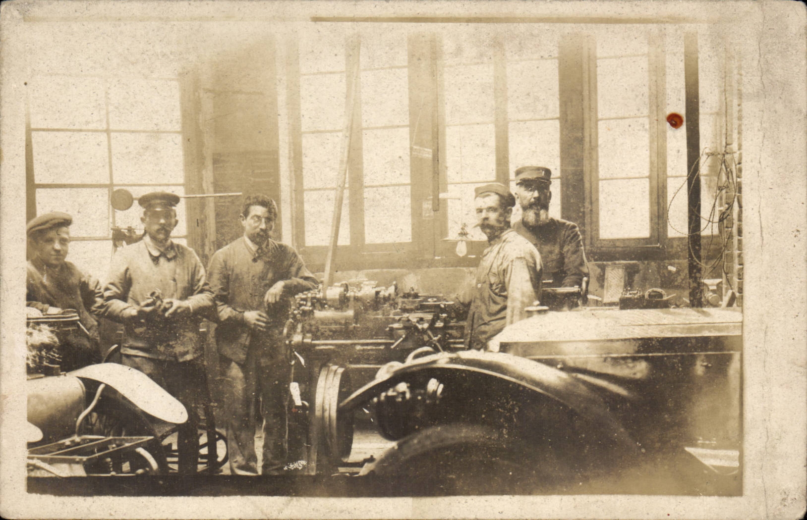 Atelier de mécanique — travailleurs autour d'un moteur — éditeur non identifié