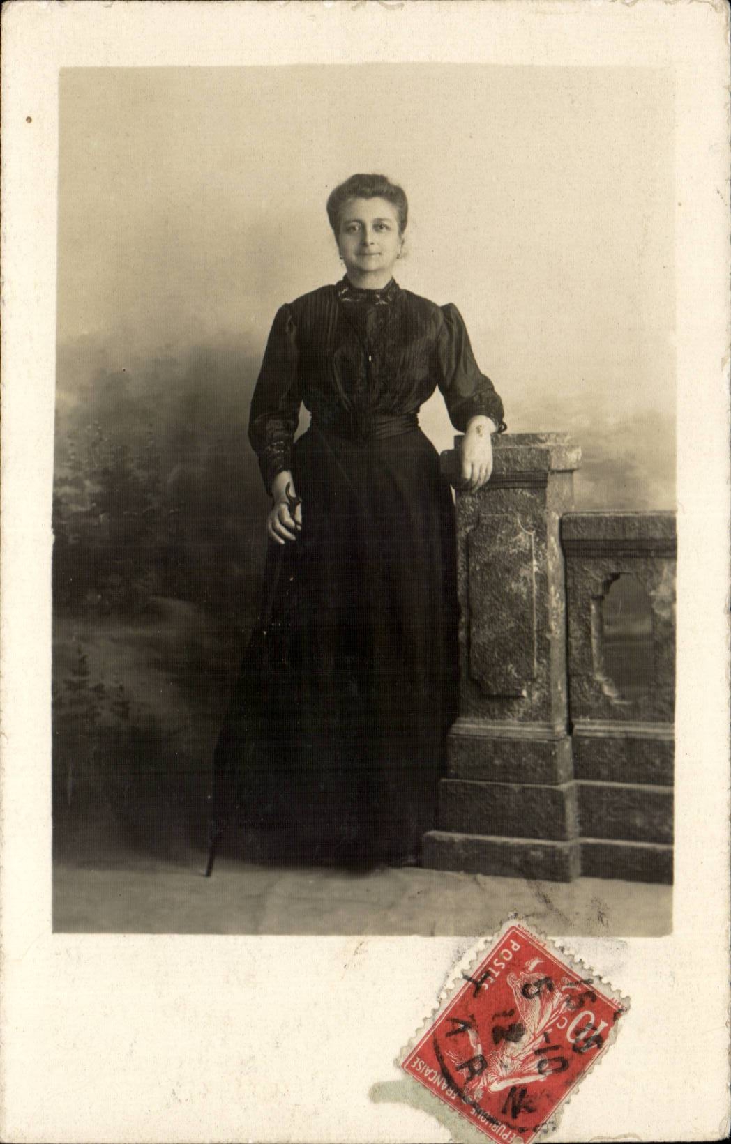 Femme en robe sombre — pose devant un décor de jardin — éditeur inconnu