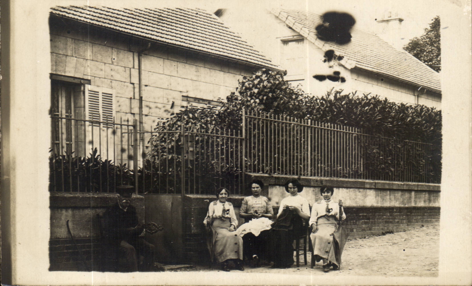 Quattro donne sedute davanti a una casa — editore non visibile