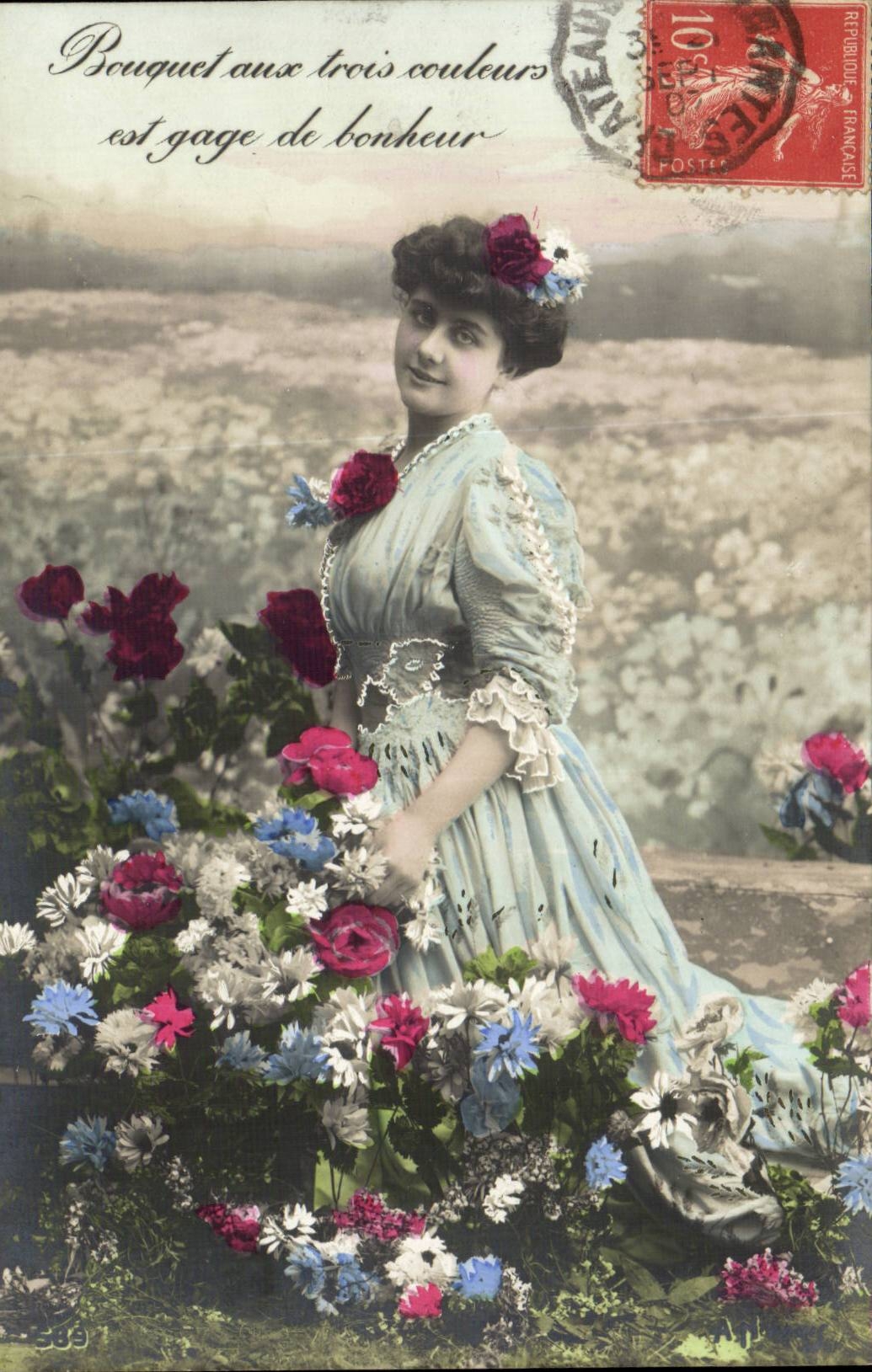 Femme en robe bleue parmi des fleurs — 'Bouquet aux trois couleurs est gage de bonheur' — éditeur non visible, n° de série 589
