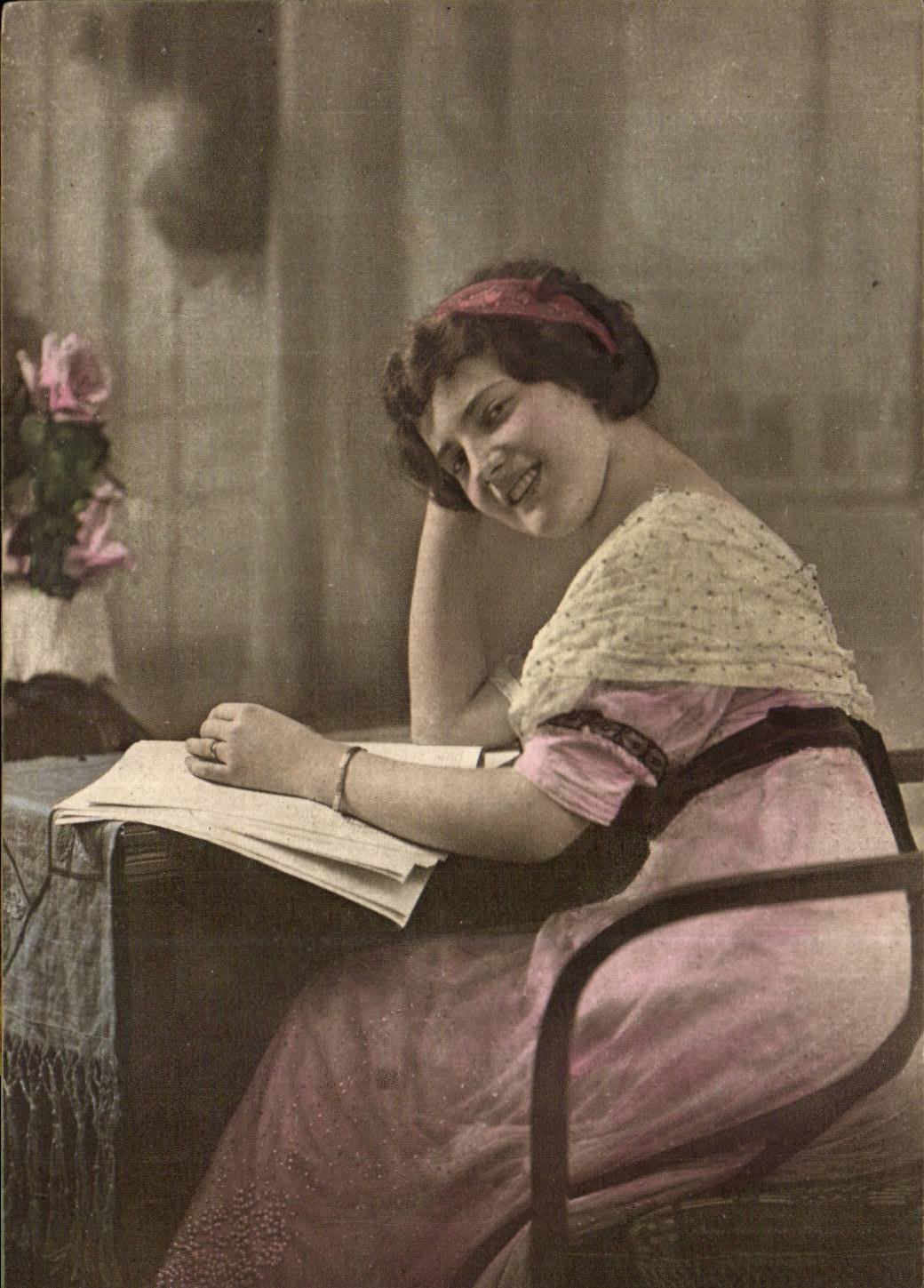 Jeune femme souriante lisant — carte postale colorisée — éditeur WRECKS, n° 011