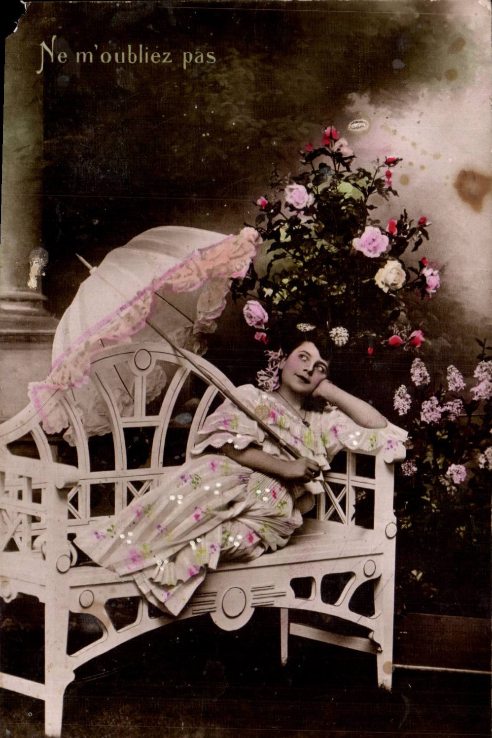Femme assise sur un banc — avec parasol et fleurs — texte 'Ne m'oubliez pas' — éditeur non visible