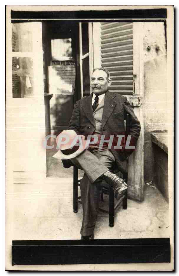 Homme à moustache assis — devant une porte avec volets — Manouze Photo