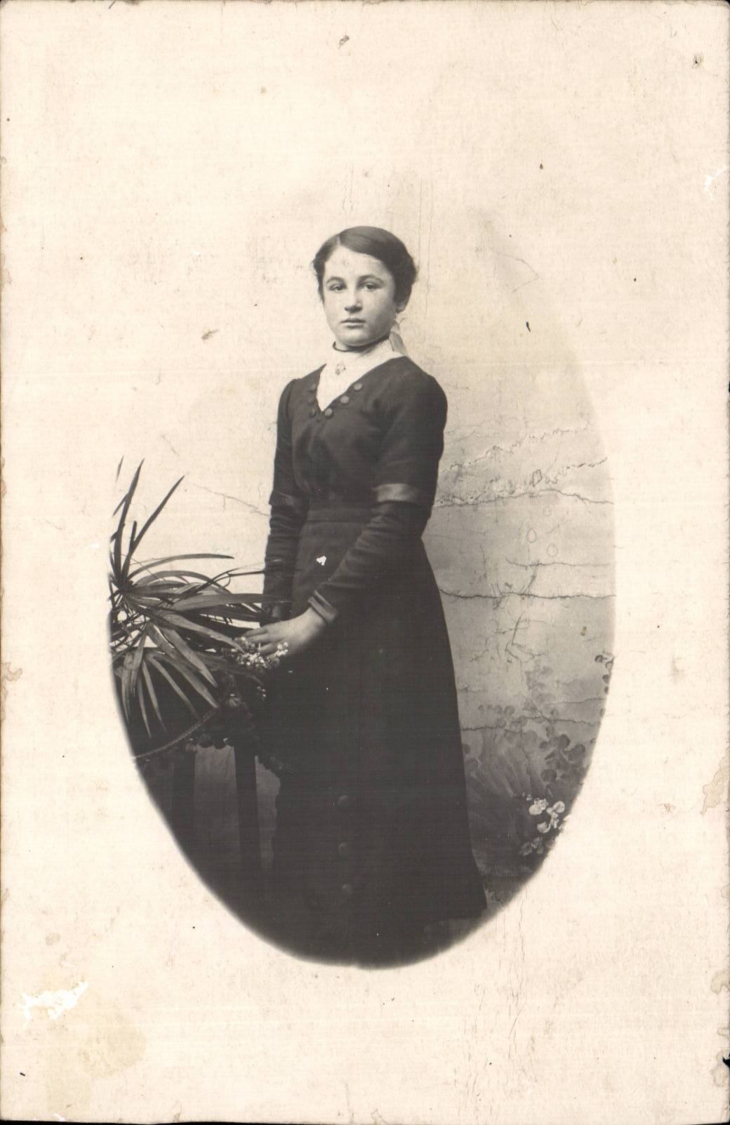 Jeune femme en robe sombre — avec plante — carte postale
