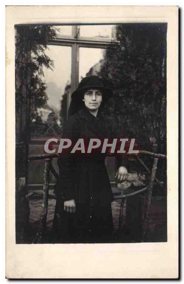 Femme en manteau et chapeau — devant un balcon en fer forgé — éditeur inconnu