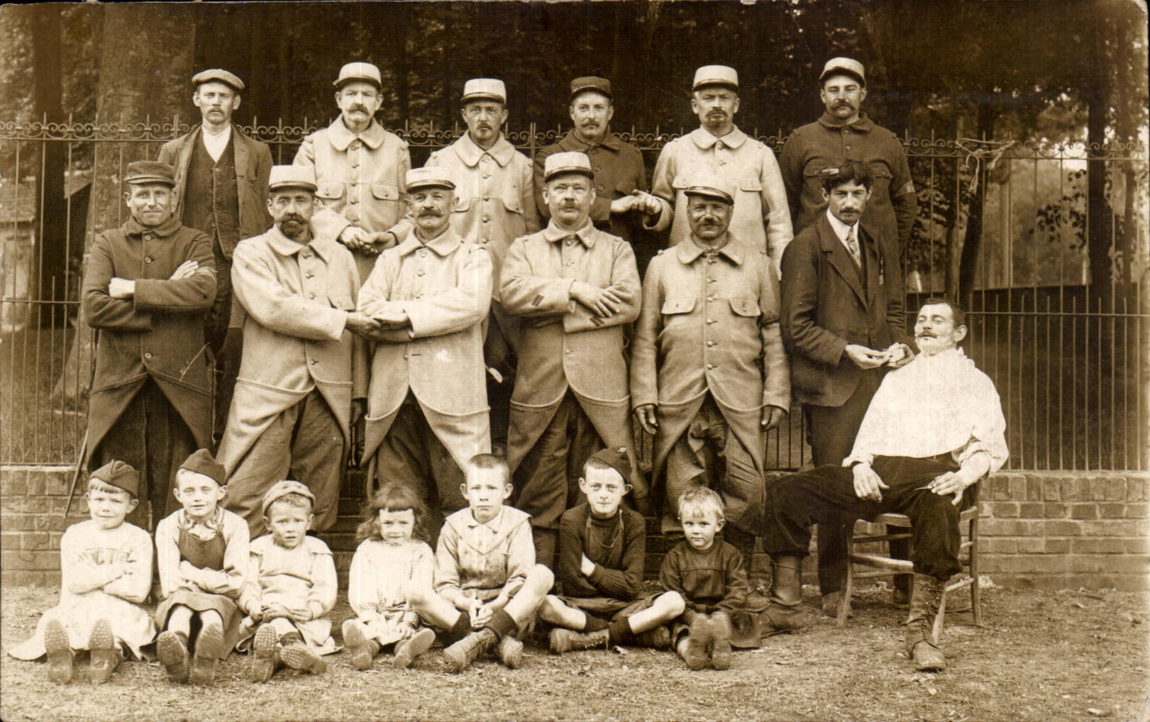 Groupe de soldats et enfants — devant une grille — éditeur STAMP, n° 143