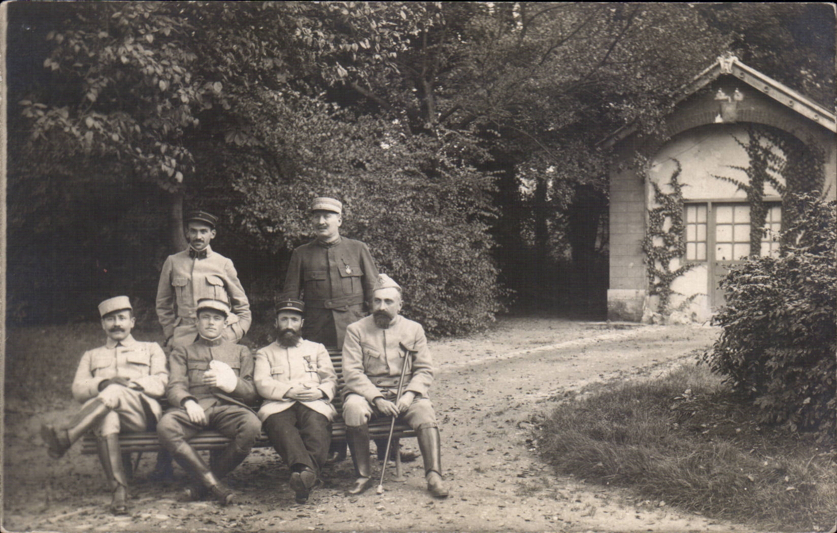 Groupe de soldats en uniforme — jardin avec petite maison — éditeur non visible
