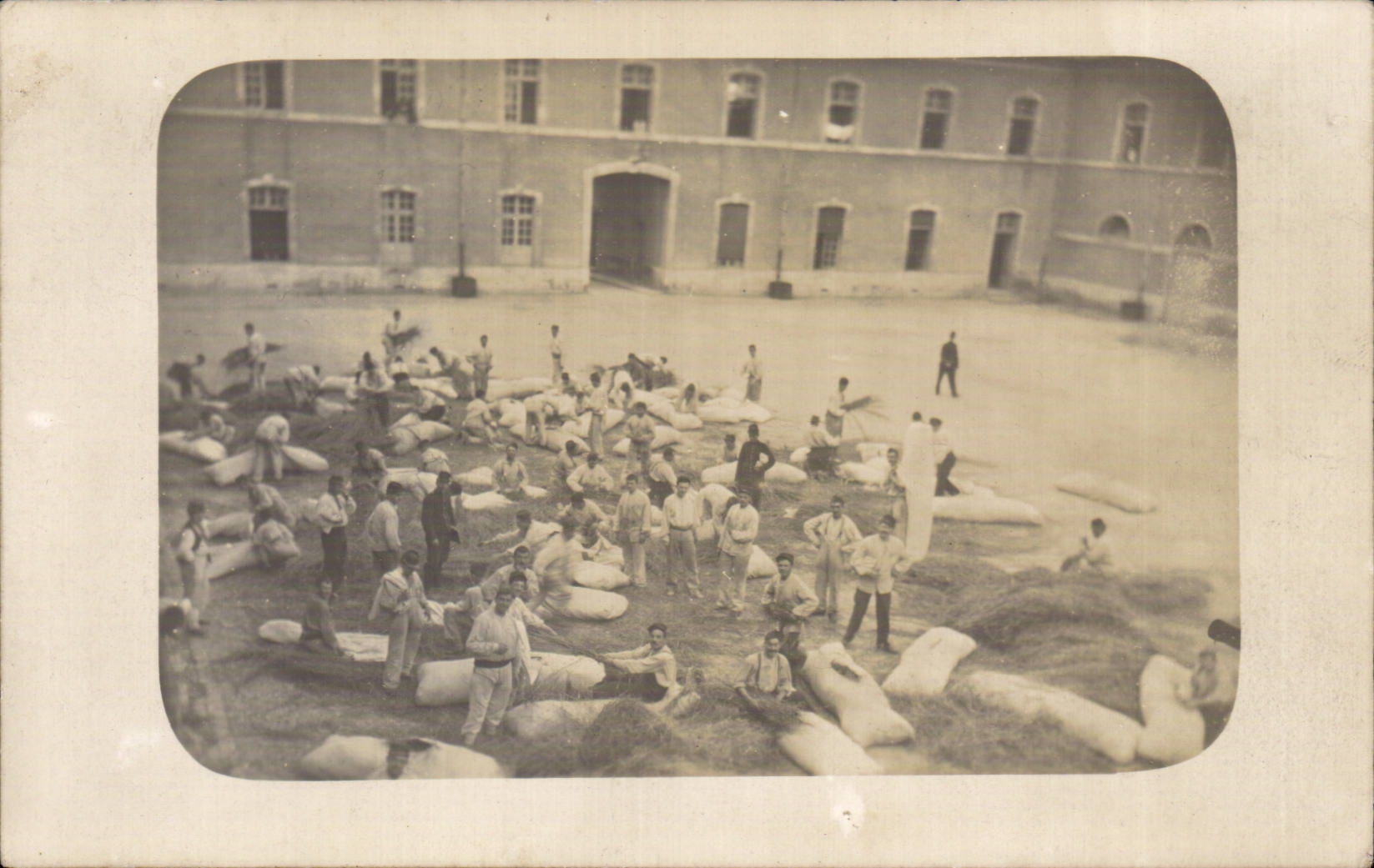 Cour d'un bâtiment militaire — soldats manipulant des ballots — B. Gaillardon, Paris