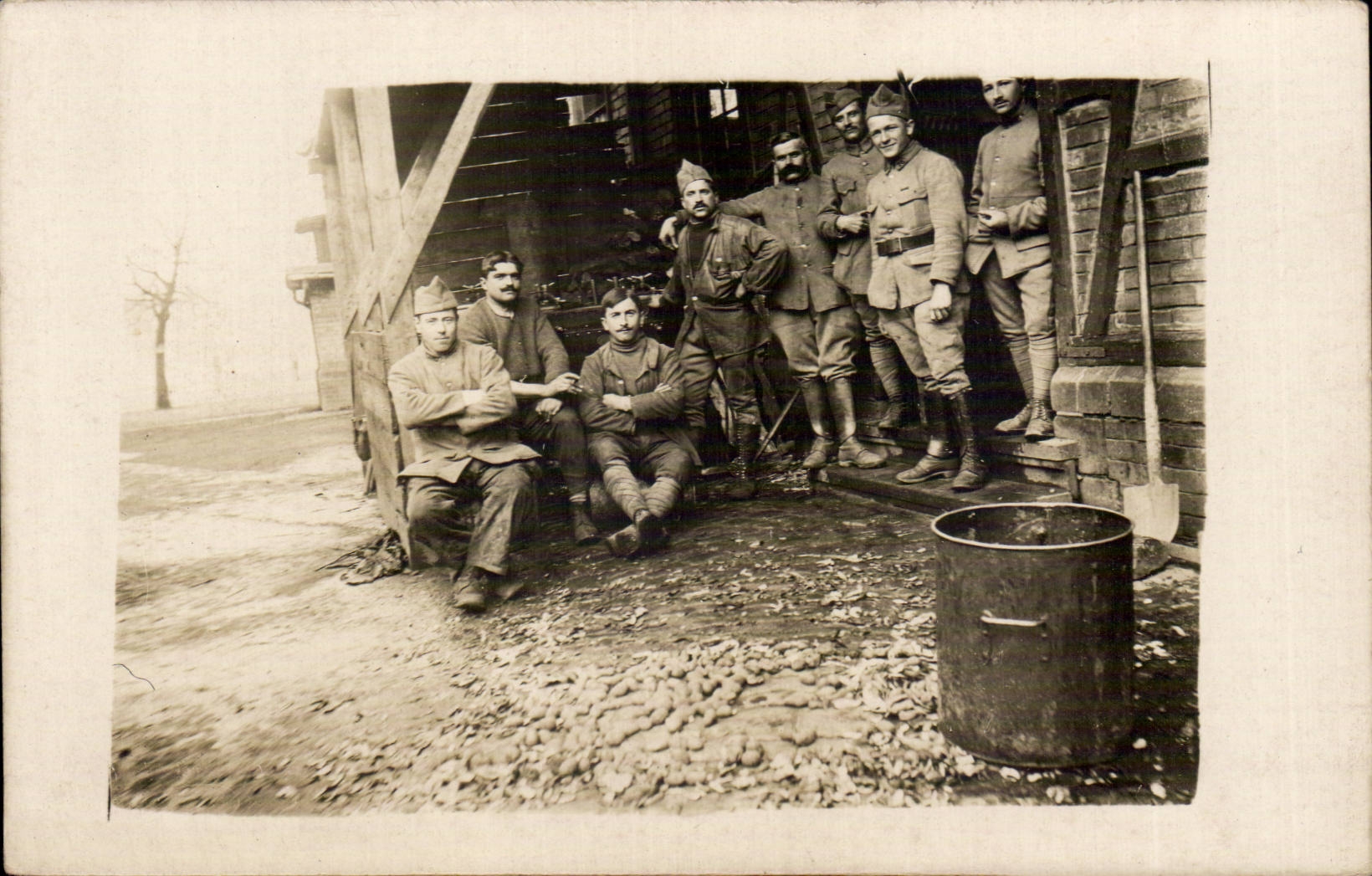 Groupe de soldats — devant une structure en bois et briques — éditeur CPAPHIL, n° de série non visible