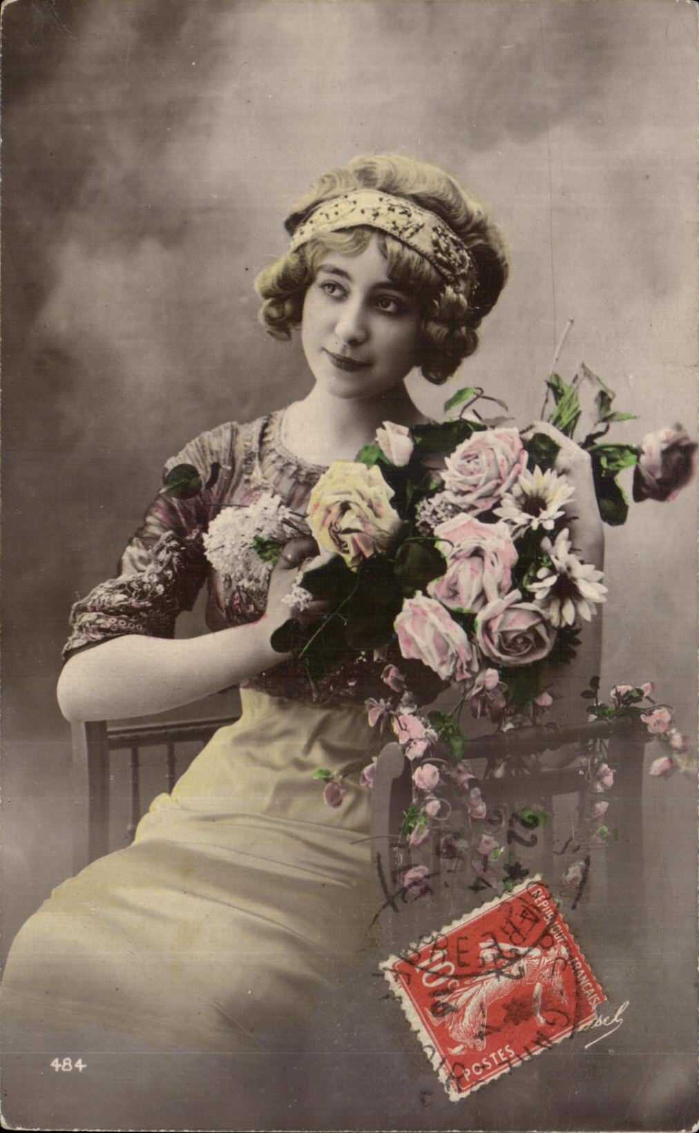 Jeune femme en robe à motifs — tenant un bouquet de roses — éditée par POSTES FRANÇAISES n° 484