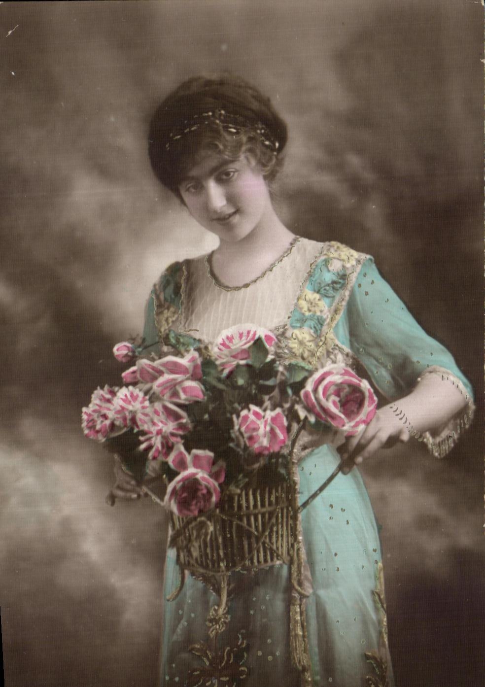 Jeune femme en robe bleue tenant un panier de roses — carte postale ancienne