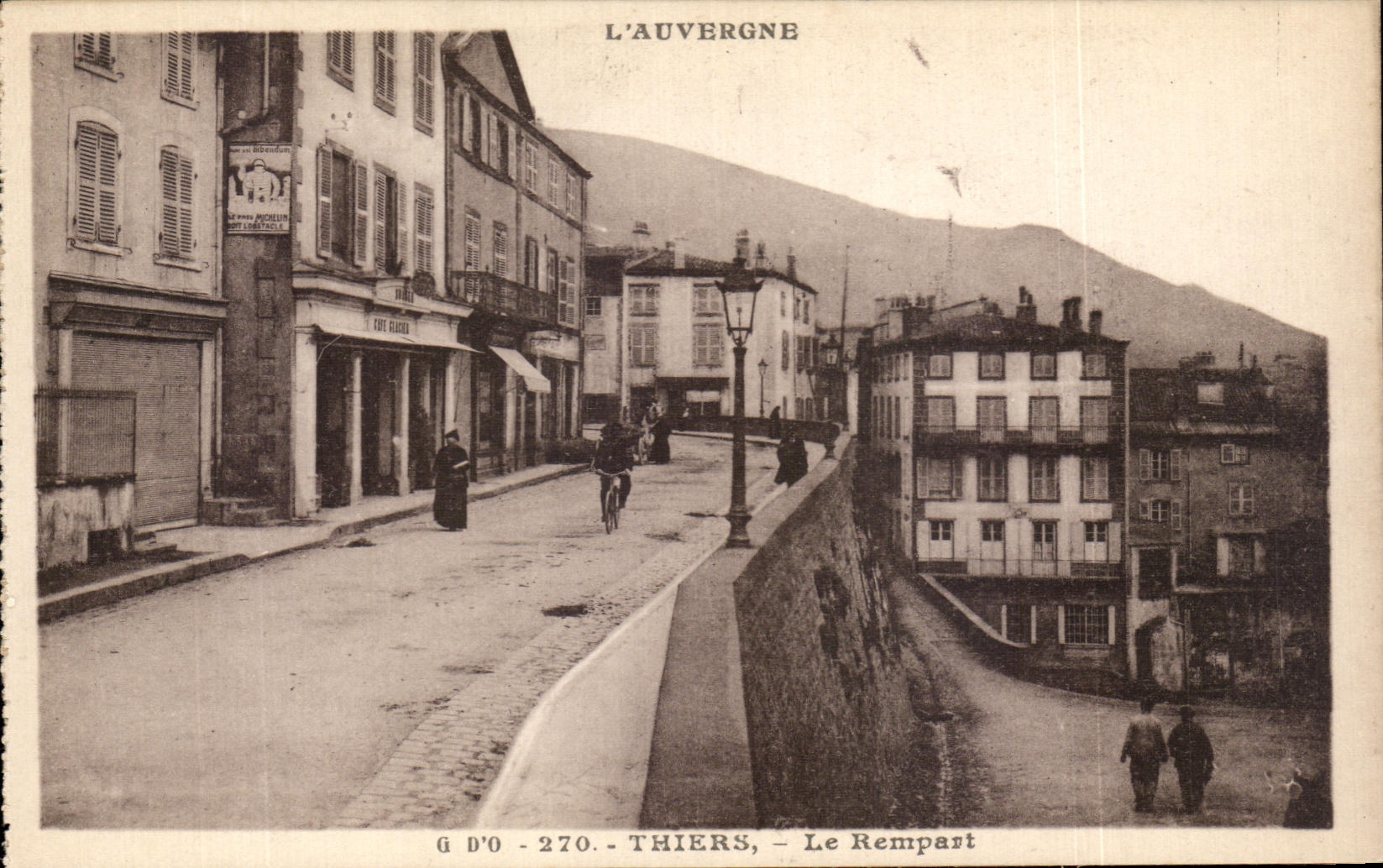 Thiers - Le Rempart — vue de la rue avec café et montagne en arrière-plan — G D'O, n°270