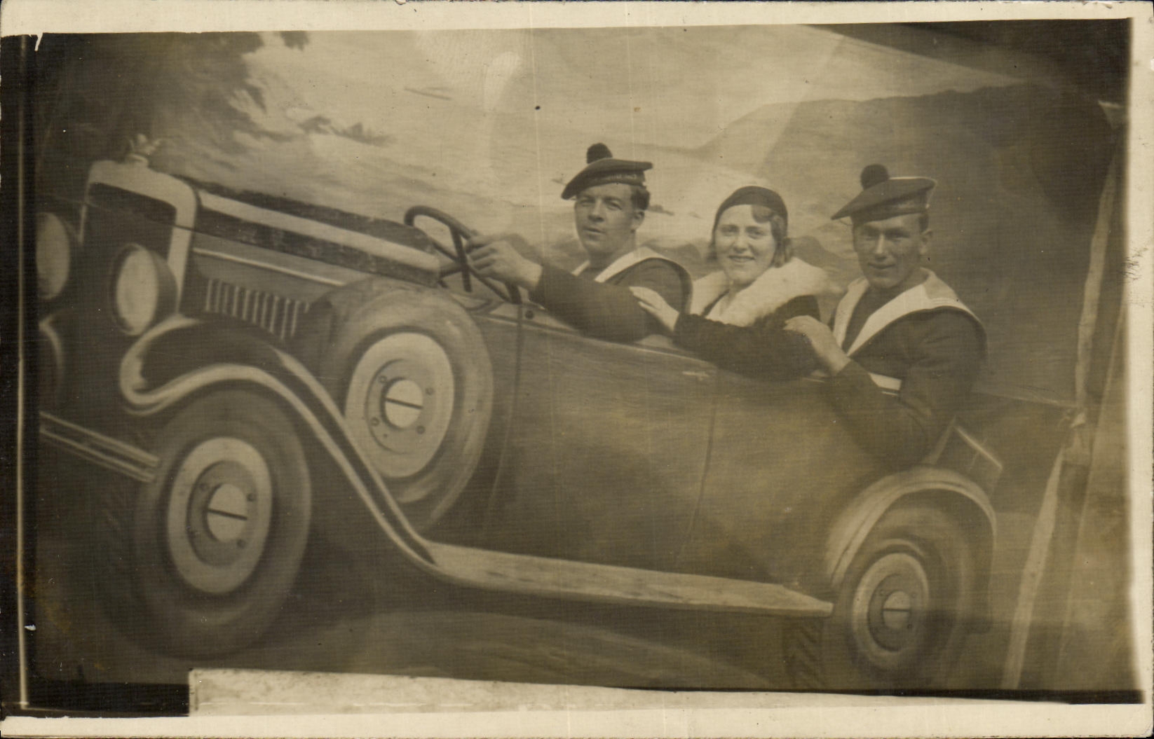 Three people in sailor uniforms in a car — Postcard from 1928