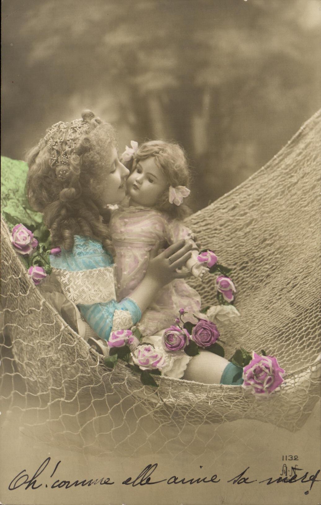 Niña que besa a una muñeca en una hamaca — rosas — Editor A.N. n°1132